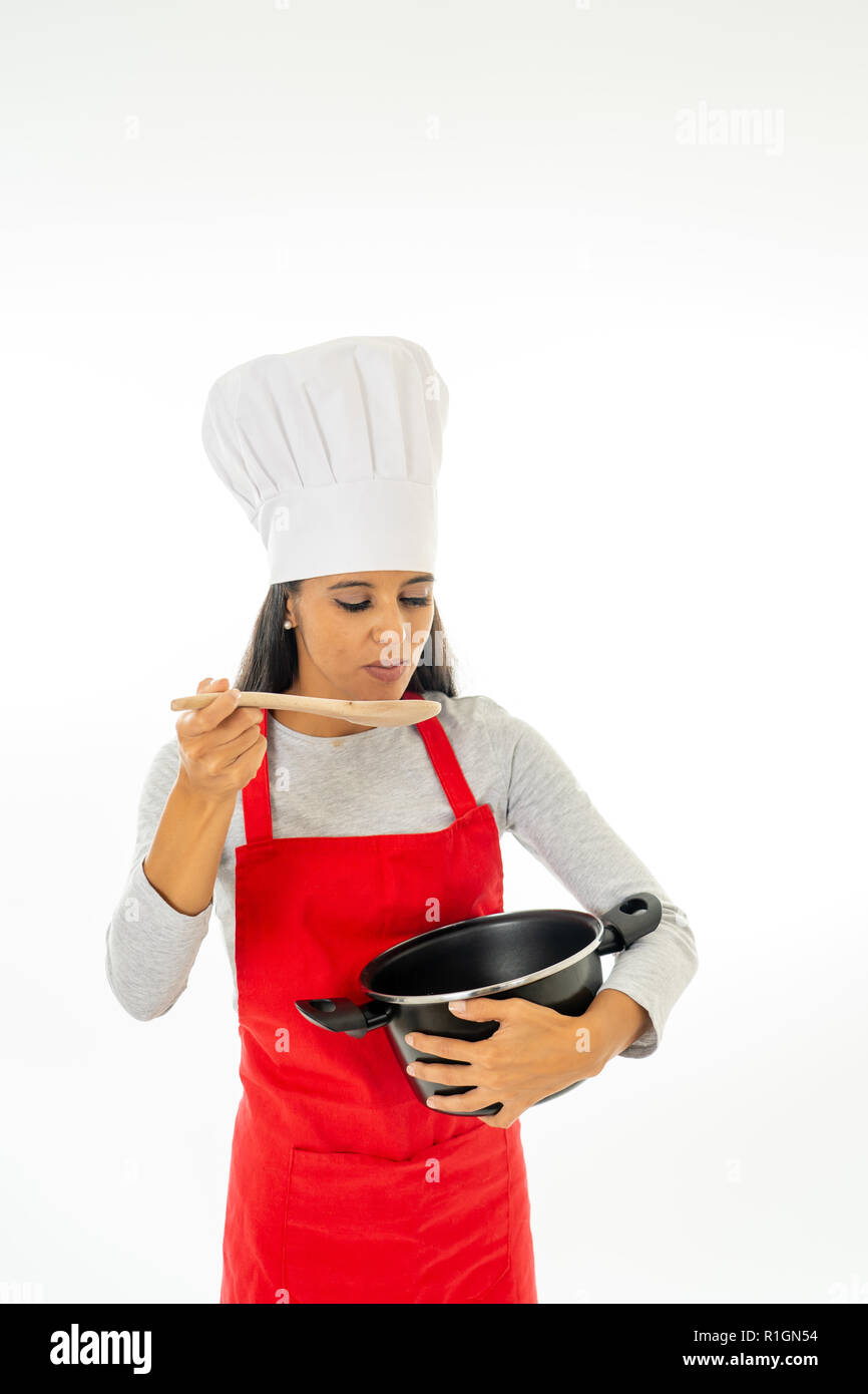 Retrato de mujer de cocción removiendo con una cuchara de madera en la cazuela haciendo una comida deliciosa en clase de cocina, alimentos saludables, ser un chef y cocina casera co Foto de stock