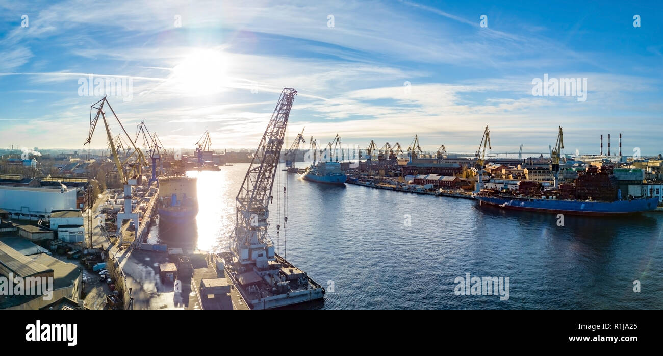 Vista aérea; zumbido de puerto con el astillero siluetas en el horizonte; paisaje industrial en tiempo soleado con cielo azul; proceso de reparación naval, l Foto de stock