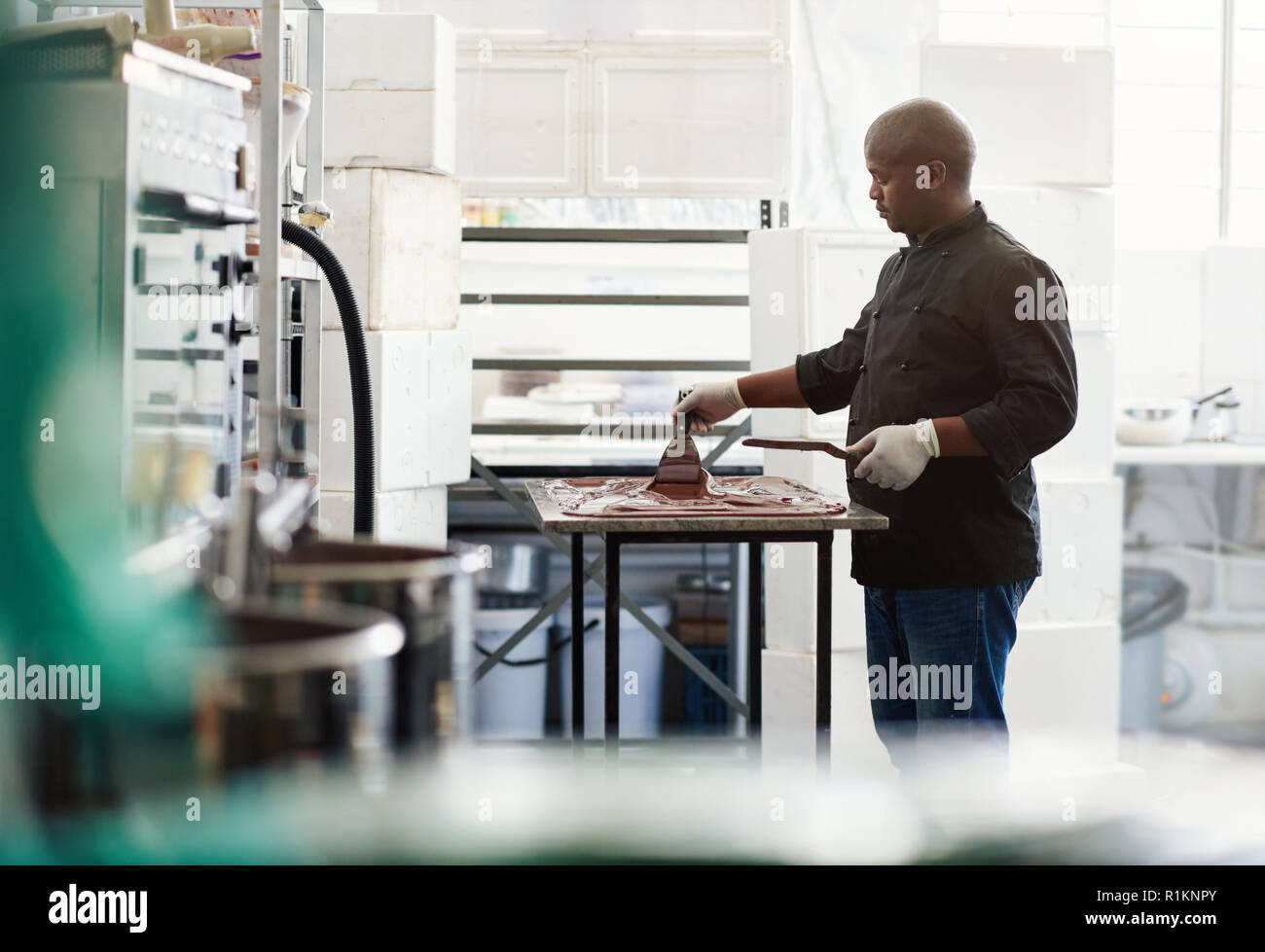 Chocolate artesanal maker trabaja en un cuadro de fábrica Foto de stock