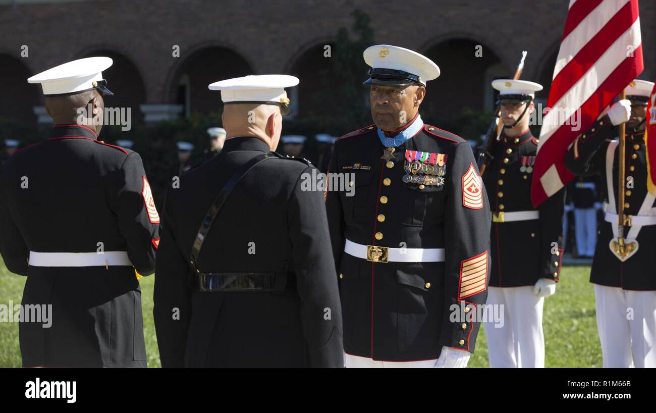 Retirado del Cuerpo de Marines de EE.UU Sgt. Gral. John L. Canley, el 298th Marine recibió la Medalla de Honor del Comandante de la Infantería de Marina Gen. Robert B. Neller y Sargento Mayor de la Infantería de Marina Ronald L. Verde, stand en la atención mientras Canley se presenta la bandera de la Medalla de Honor en el cuartel de los Marines en Washington, D.C., 19 de octubre, 2018. Desde el 31 de enero, 6 de febrero de 1968 en la República de Vietnam, Canley, la compañía al sargento primero asignado a la empresa Alfa, 1º Batallón, 01 infantes de Marina, tomó el mando de la empresa llevaron varios ataques contra posiciones fortificadas enemigas, se apresuraron a través de fuego-barrida de terreno Foto de stock