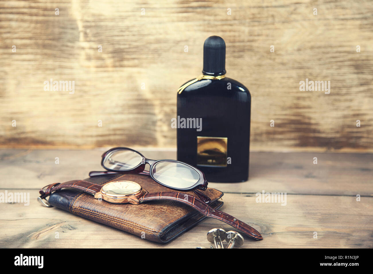 Ya que comportarse Atticus Relojes,gafas, monedero y perfume sobre fondo de madera Fotografía de stock  - Alamy