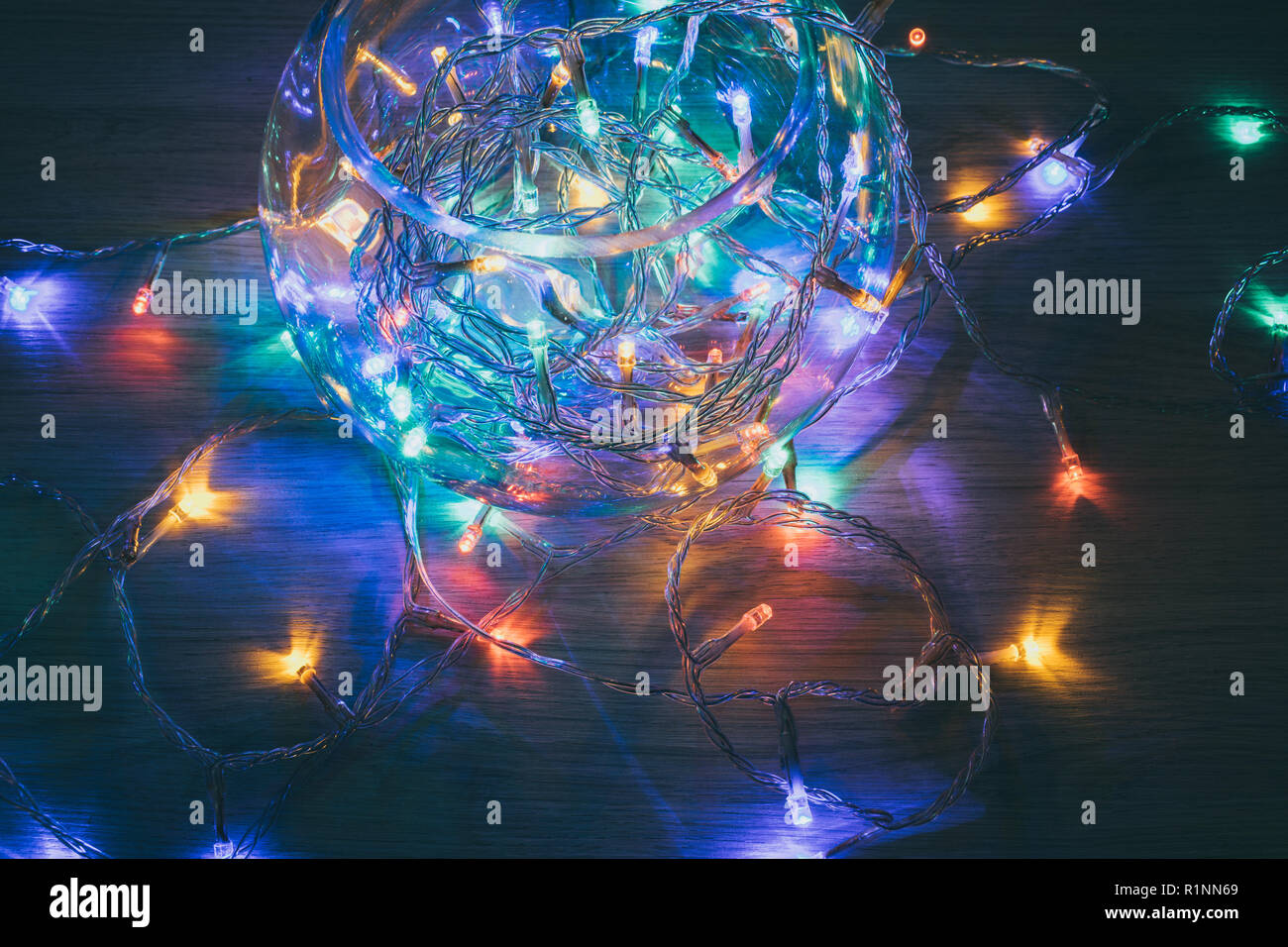 Las luces de navidad dentro de una bola de cristal sobre un fondo de madera. Decoración de Navidad Foto de stock