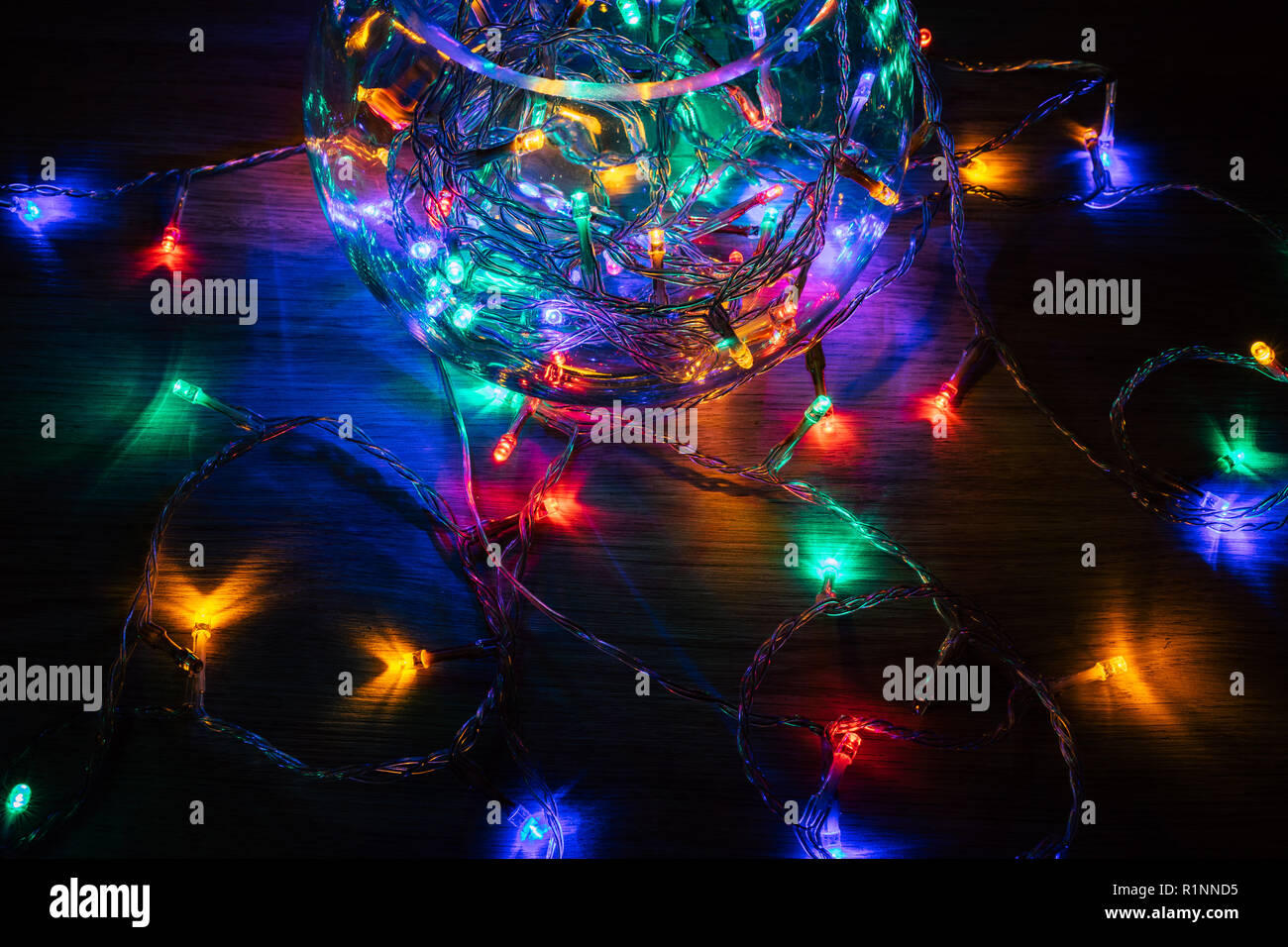 Las luces de navidad dentro de una bola de cristal sobre un fondo de madera. Decoración de Navidad Foto de stock