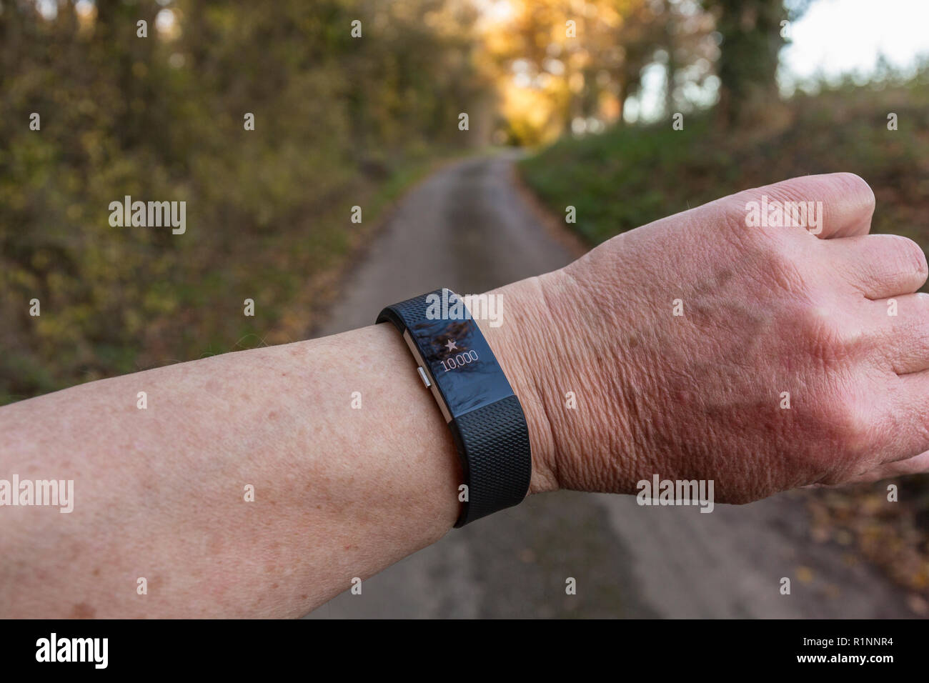 Estrellas para anunciar 10.000 pasos en un Fitbit, fitness tracker, subiendo por un carril del país. Foto de stock