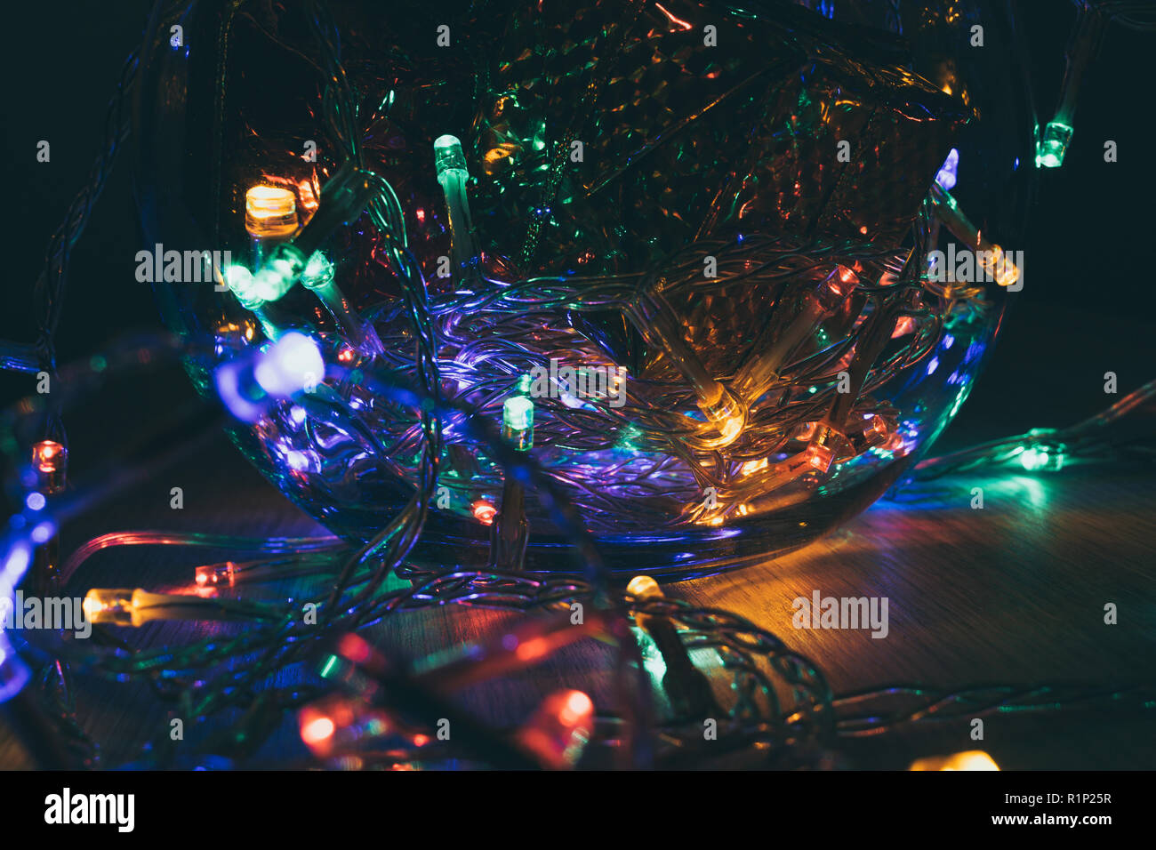 Las luces de navidad dentro de una bola de cristal sobre un fondo de madera. Decoración de Navidad Foto de stock