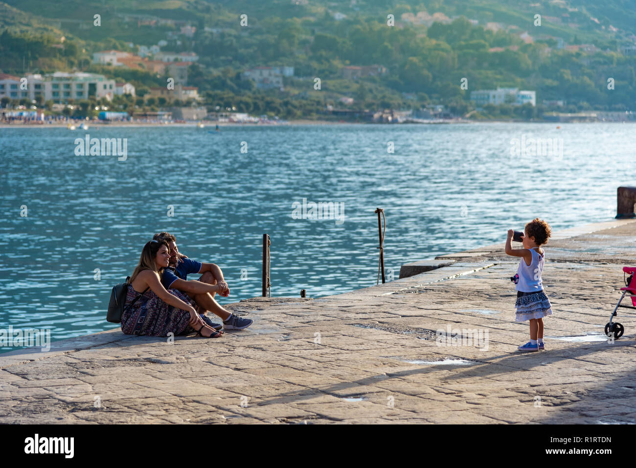 Sicilia, Italia - 14 de agosto de 2018: familia feliz en la playa de la ciudad de Cefalu, tomando fotografías en seaside Foto de stock