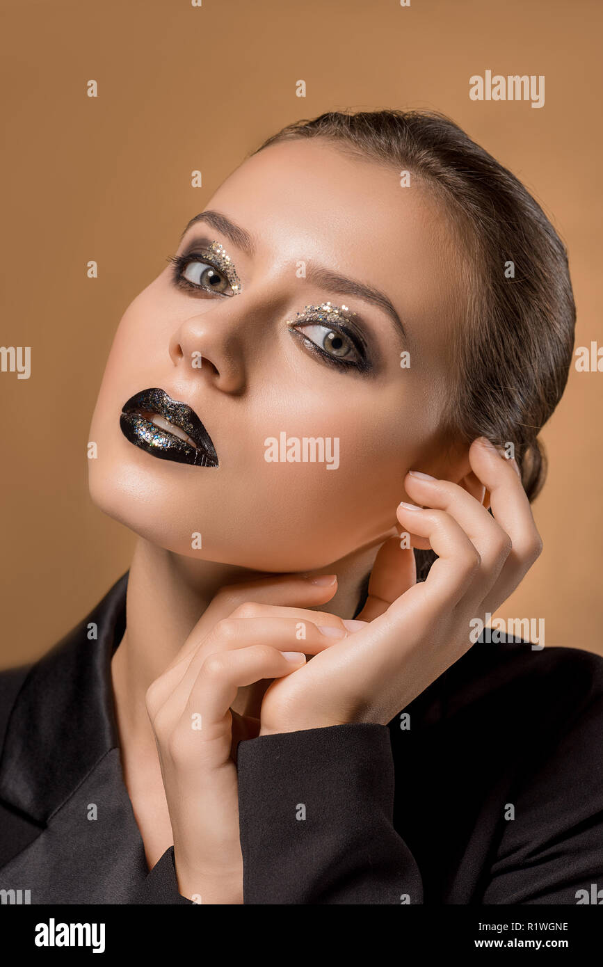 Hermosa mujer joven maquillaje glitter y las manos cerca de la cara Fotografía de - Alamy