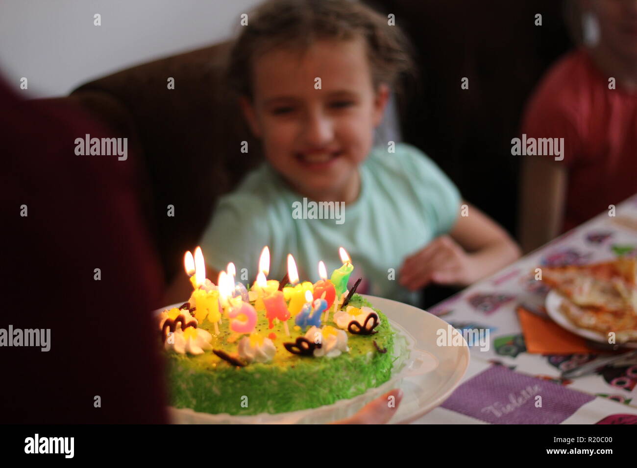 Los niños felices a una chica de la fiesta de cumpleaños Foto de stock