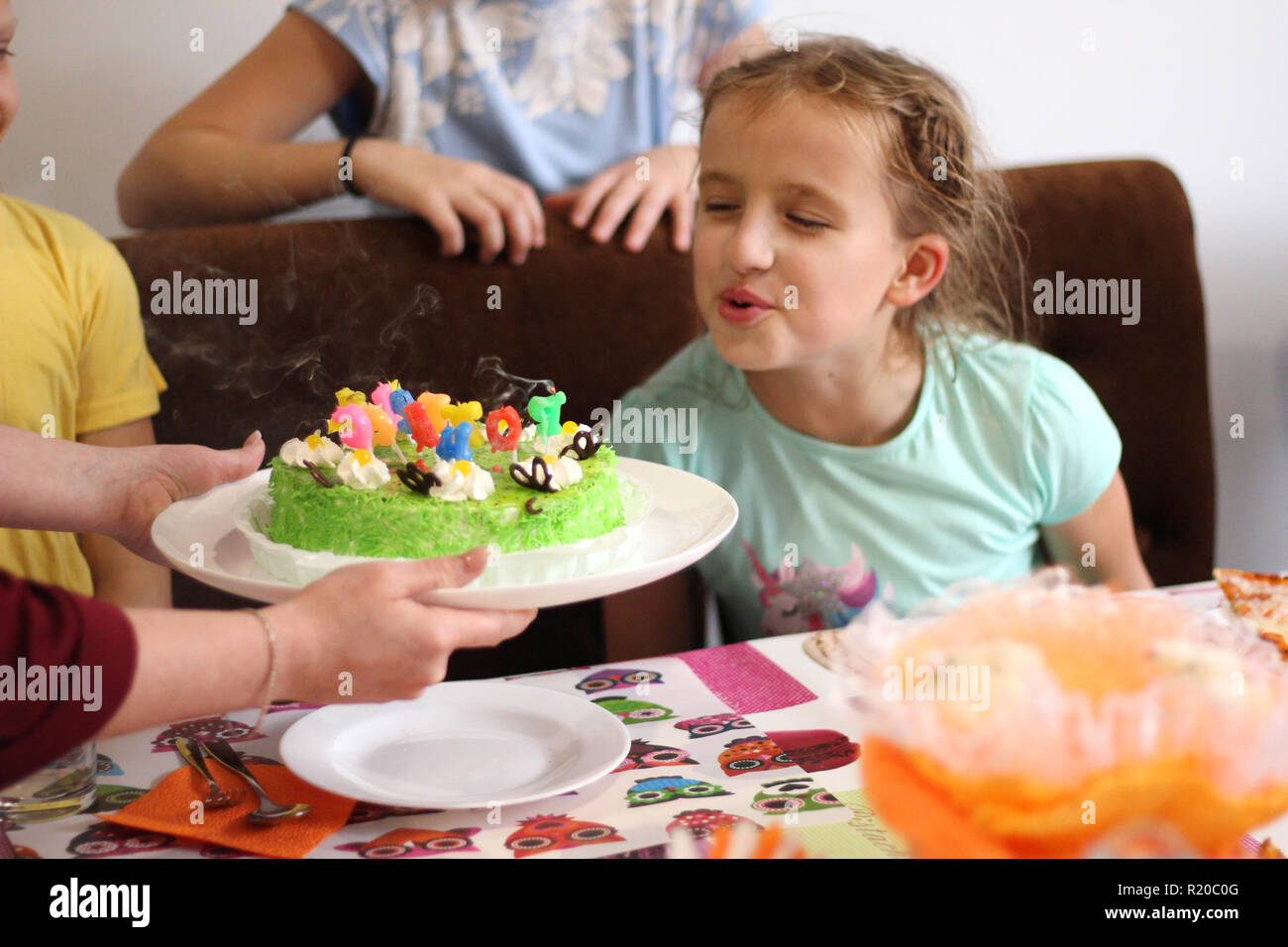 Los niños felices a una chica de la fiesta de cumpleaños Foto de stock