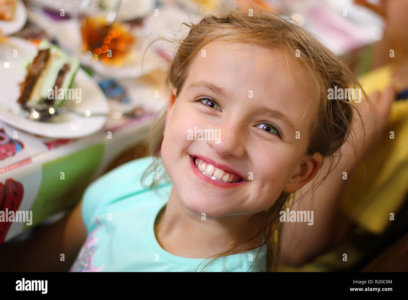 Los niños felices a una chica de la fiesta de cumpleaños Foto de stock