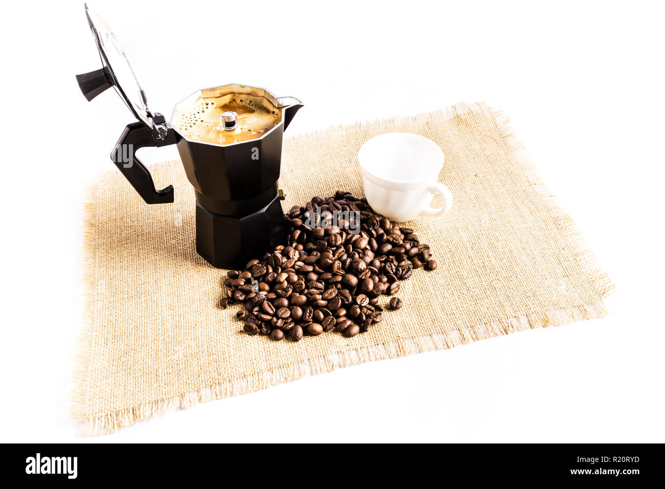 Los granos de café al lado de una cafetera italiana y una copa en un mantel  de tela Fotografía de stock - Alamy