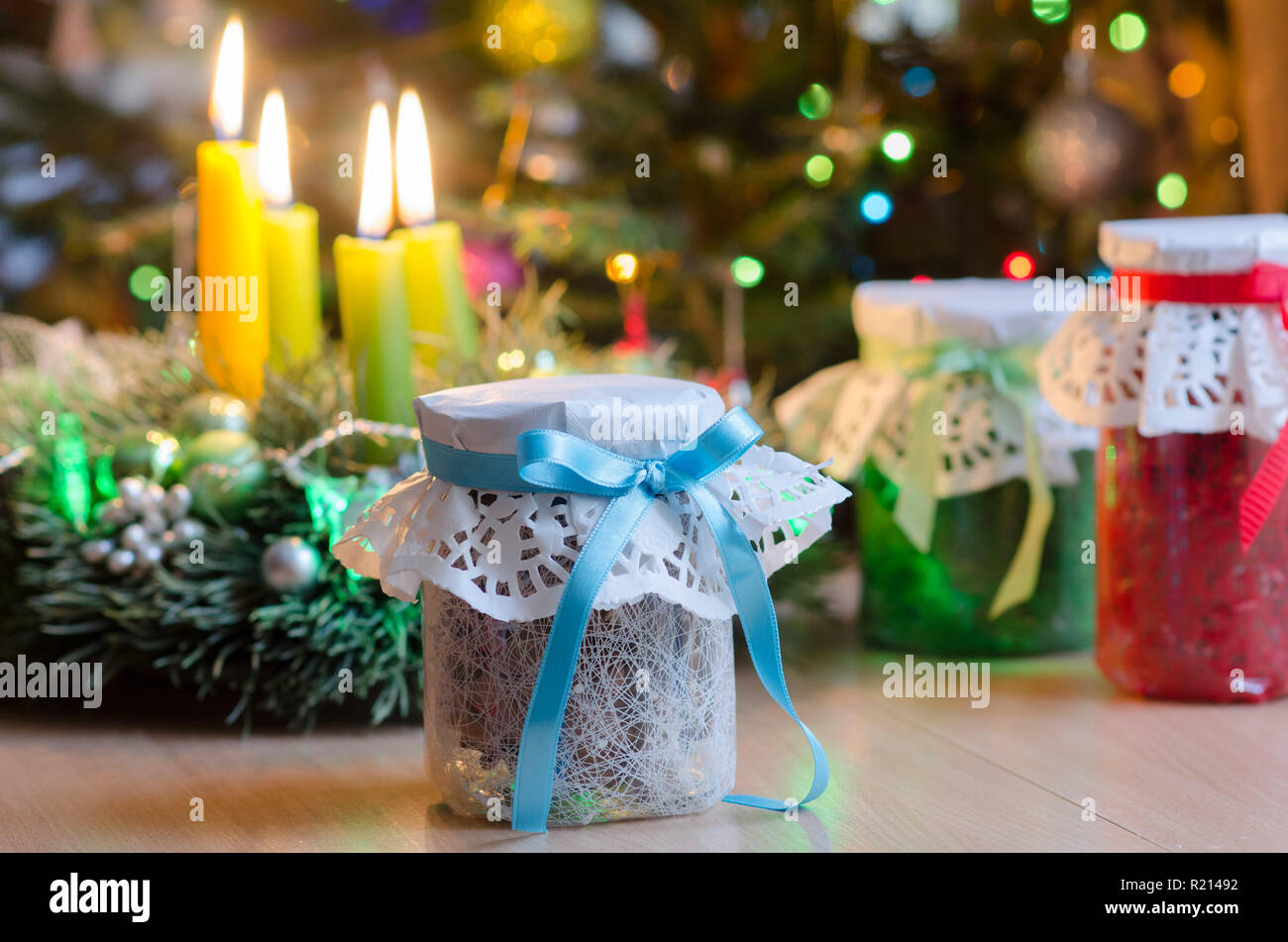 Regalos de Navidad en el fondo de ramas de Navidad velas y guirnaldas  luminosas. Regalos de Navidad. Frascos de vidrio envuelto en envoltorio de  regalo. En el Fotografía de stock - Alamy