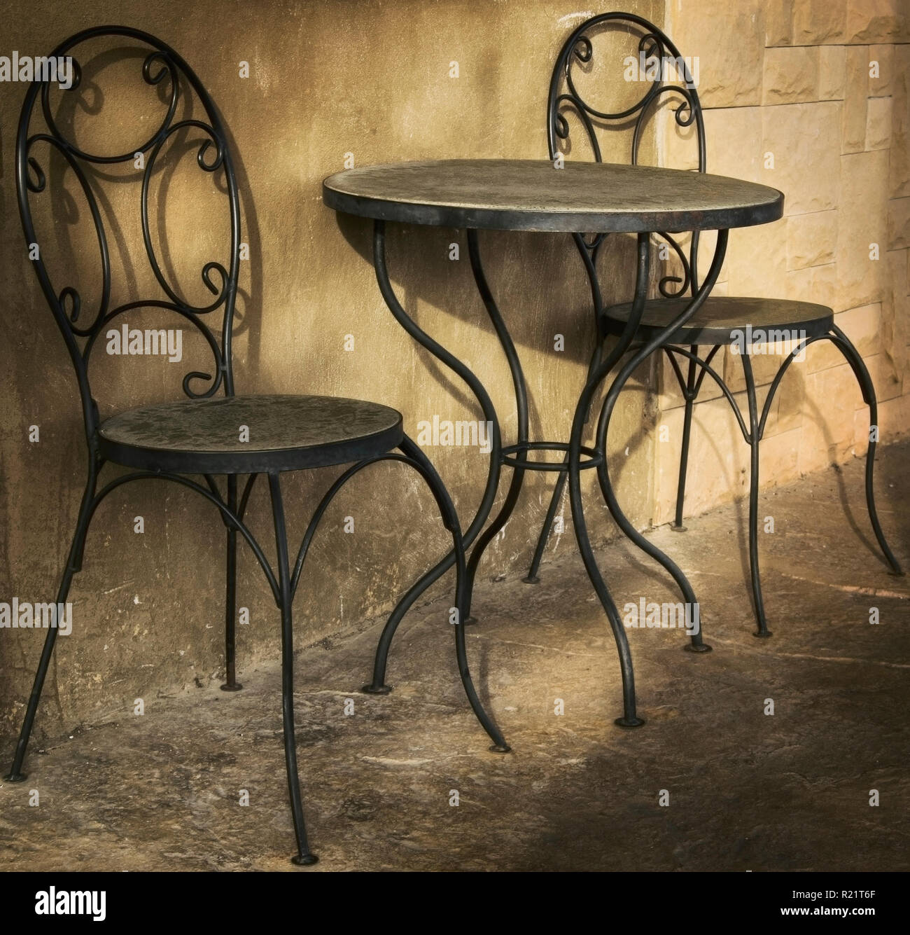 La mesa con dos sillas es el costo en la calle street cafe en parches de luz solar Foto de stock
