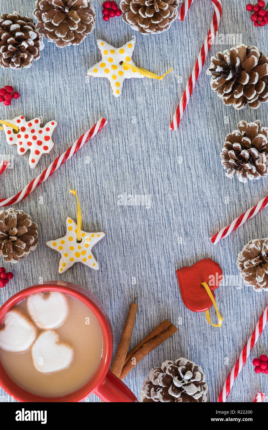 Navidad laicos plana frontera con taza de chocolate caliente, bastones de caramelo, piñas Foto de stock