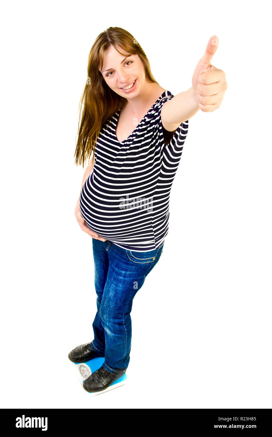 Una mujer embarazada en escalas dando un pulgar arriba Foto de stock