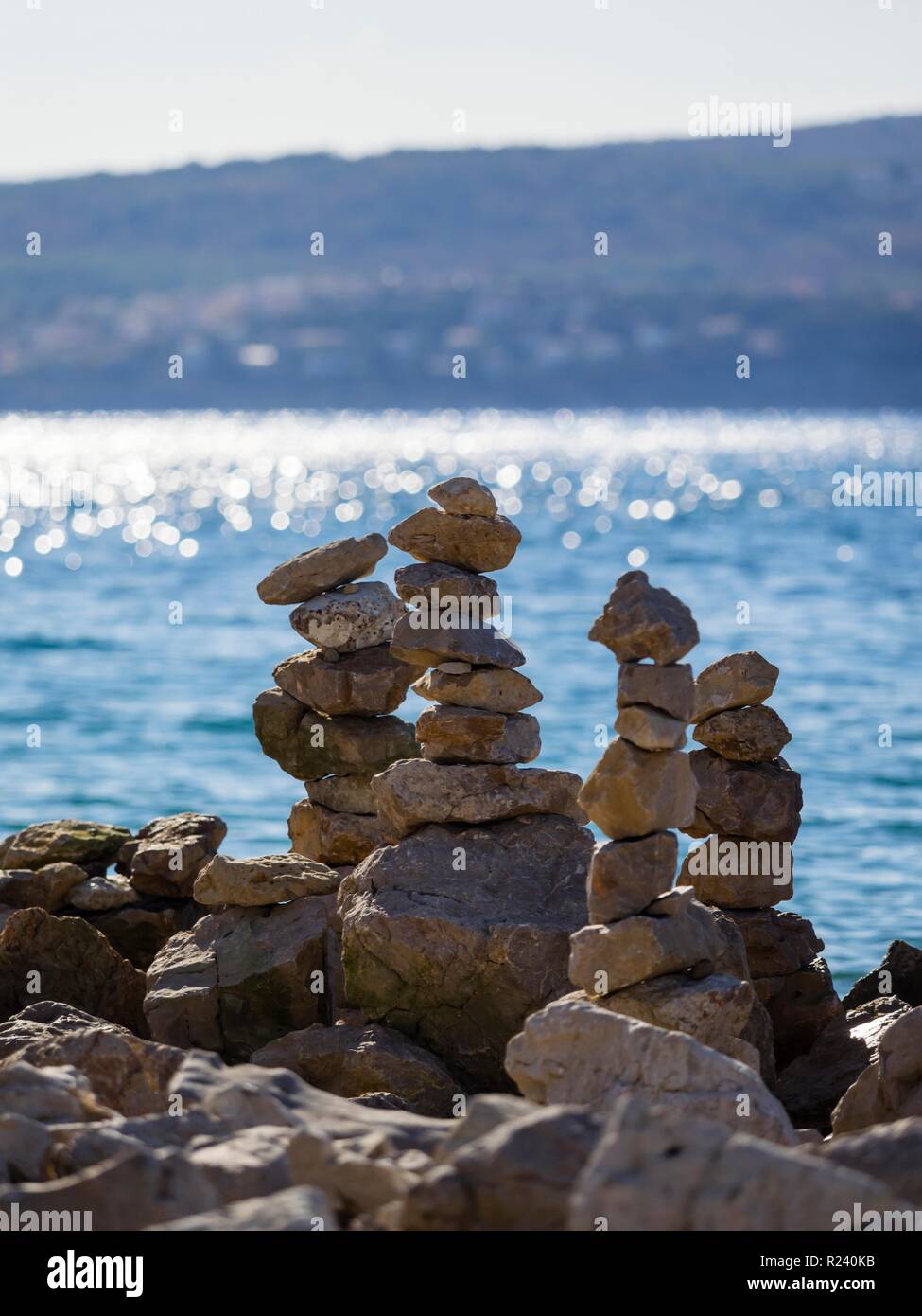 Pila de rocas en la playa contra la luz Foto de stock