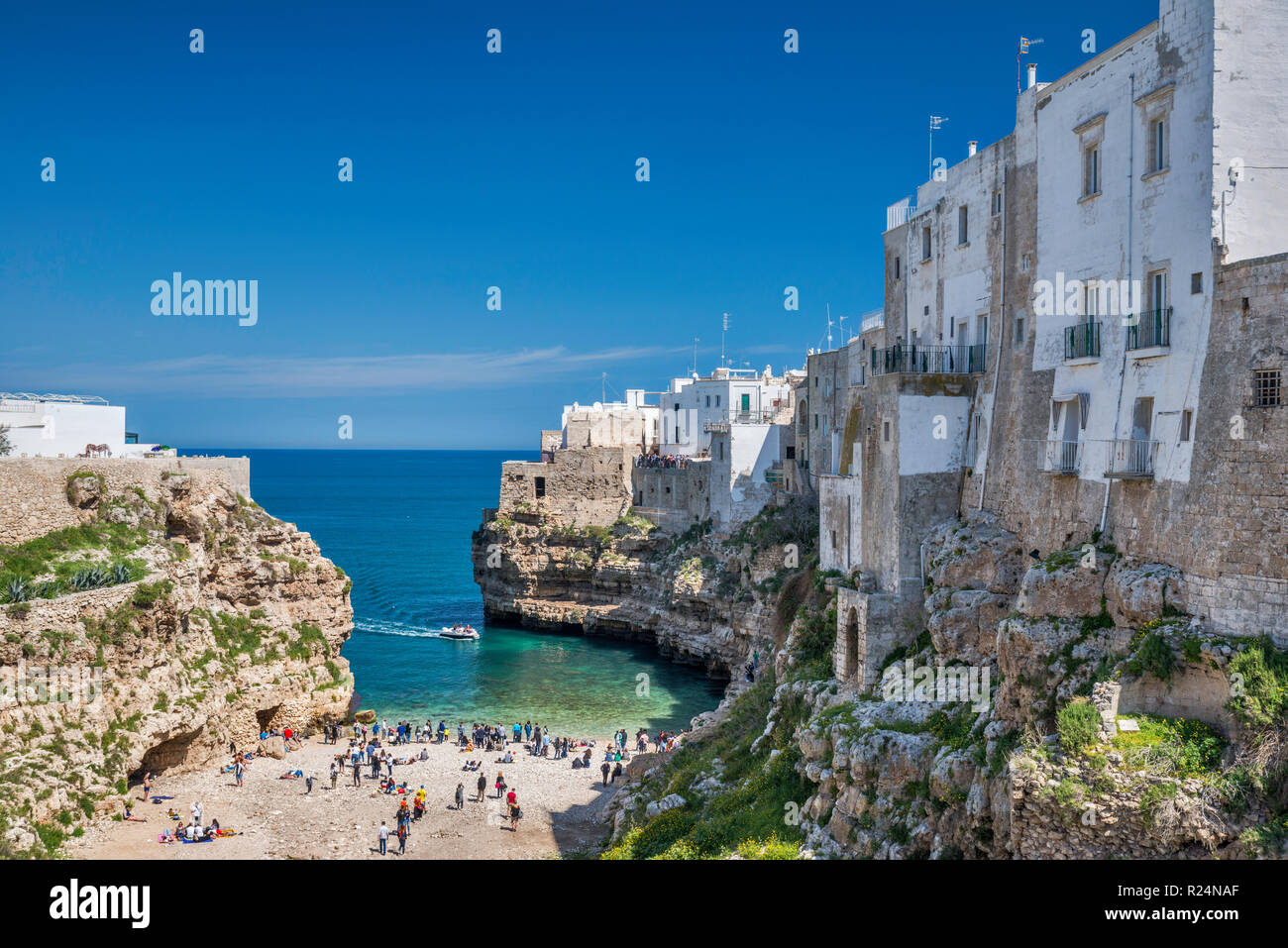 Casas encaramadas en las rocas por encima de Spiaggia di Lama Monachile, playa del Mar Adriático en Polignano a Mare, Puglia, Italia Foto de stock