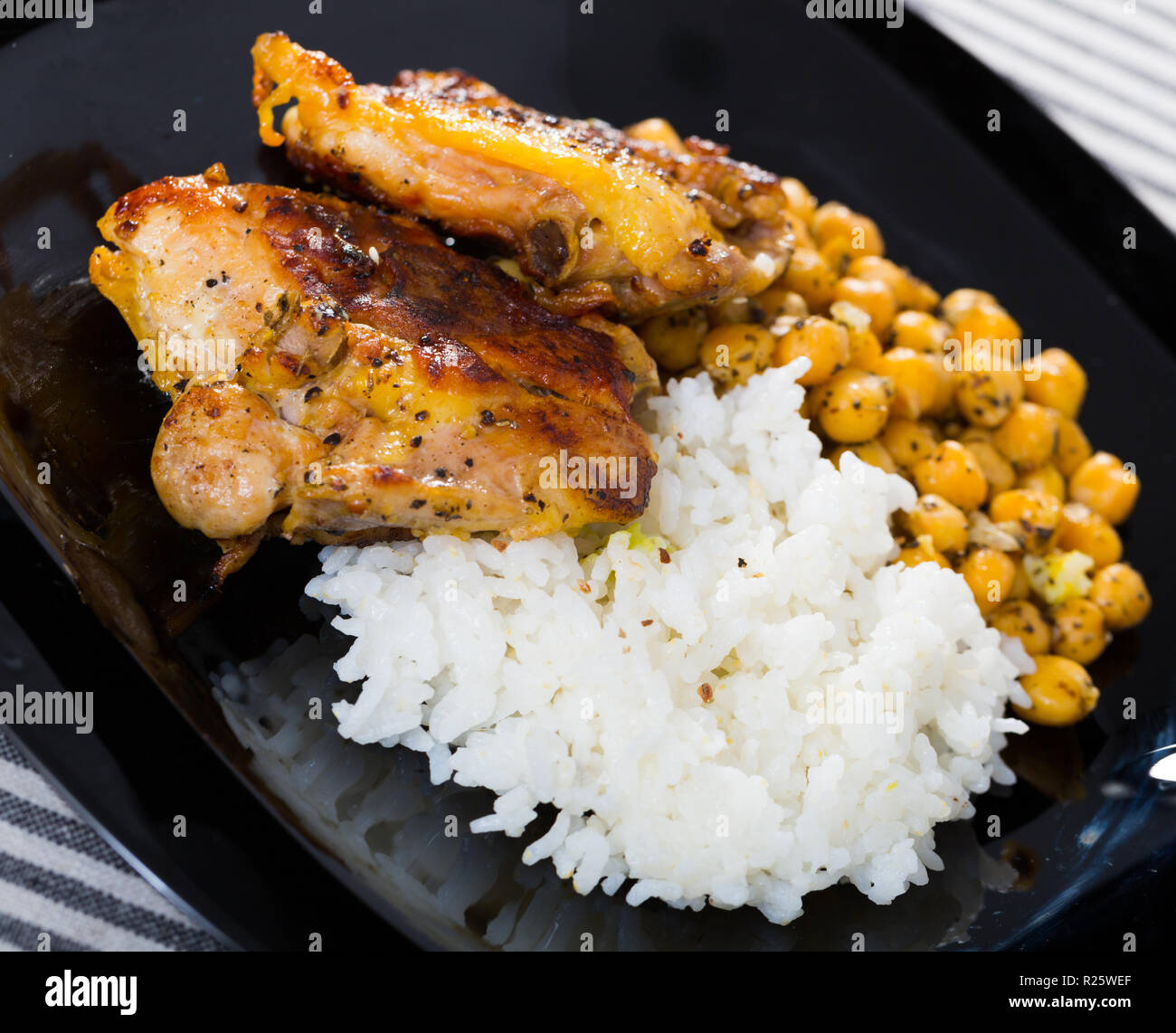 Placa con muslos de pollo horneado con arroz y garbanzos Fotografía de  stock - Alamy
