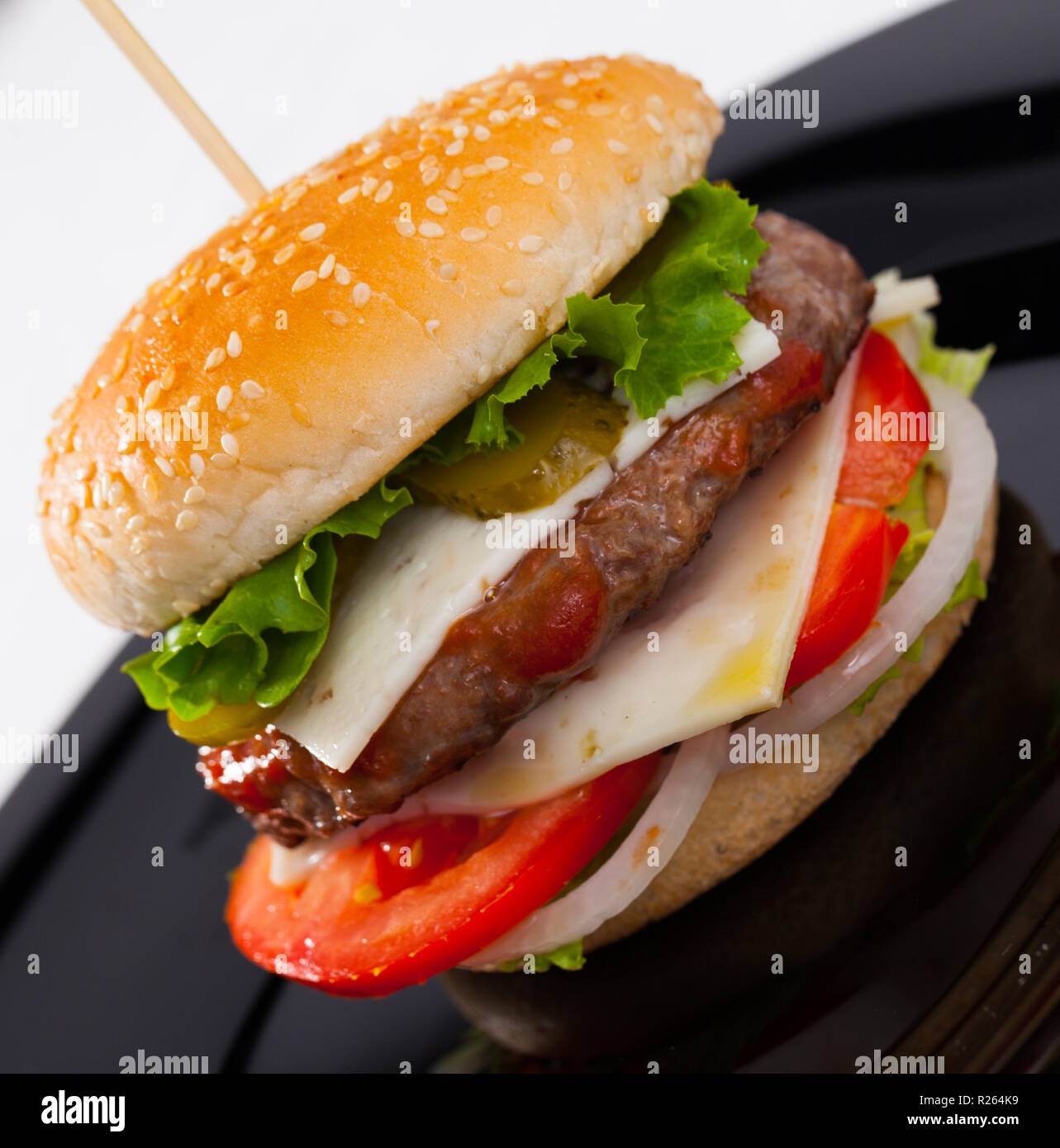 La hamburguesa es sabroso en la placa en la cocina del restaurante. La fotografía de la placa con una sabrosa hamburguesa en el restaurante. Foto de stock