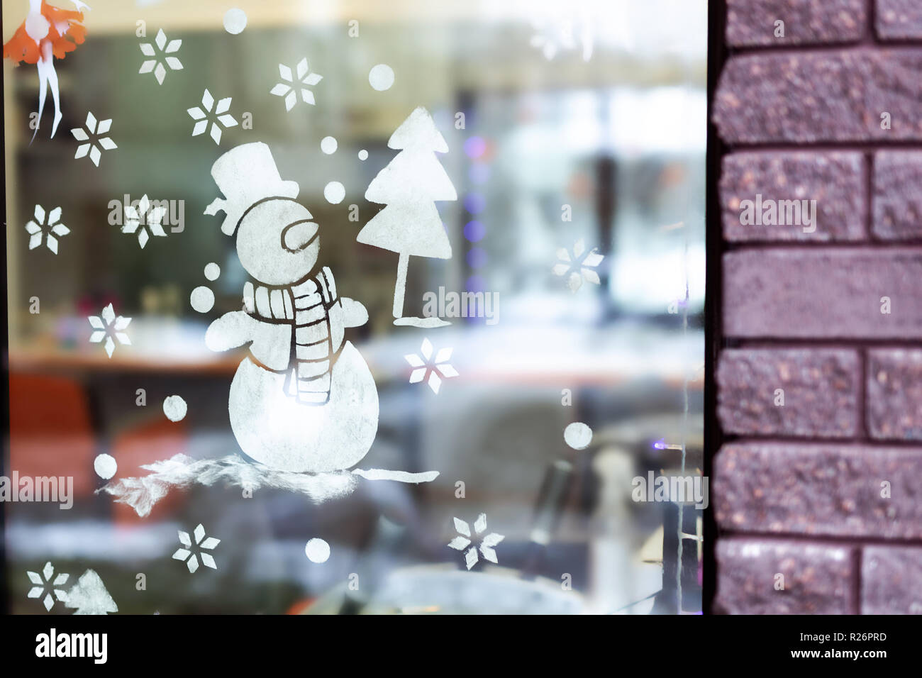 Escaparate decorado con dibujo temporal de muñeco de nieve y árbol de  Navidad hechas de nieve artificial. Vacaciones de Navidad y Año Nuevo la  decoración de la ciudad Fotografía de stock -