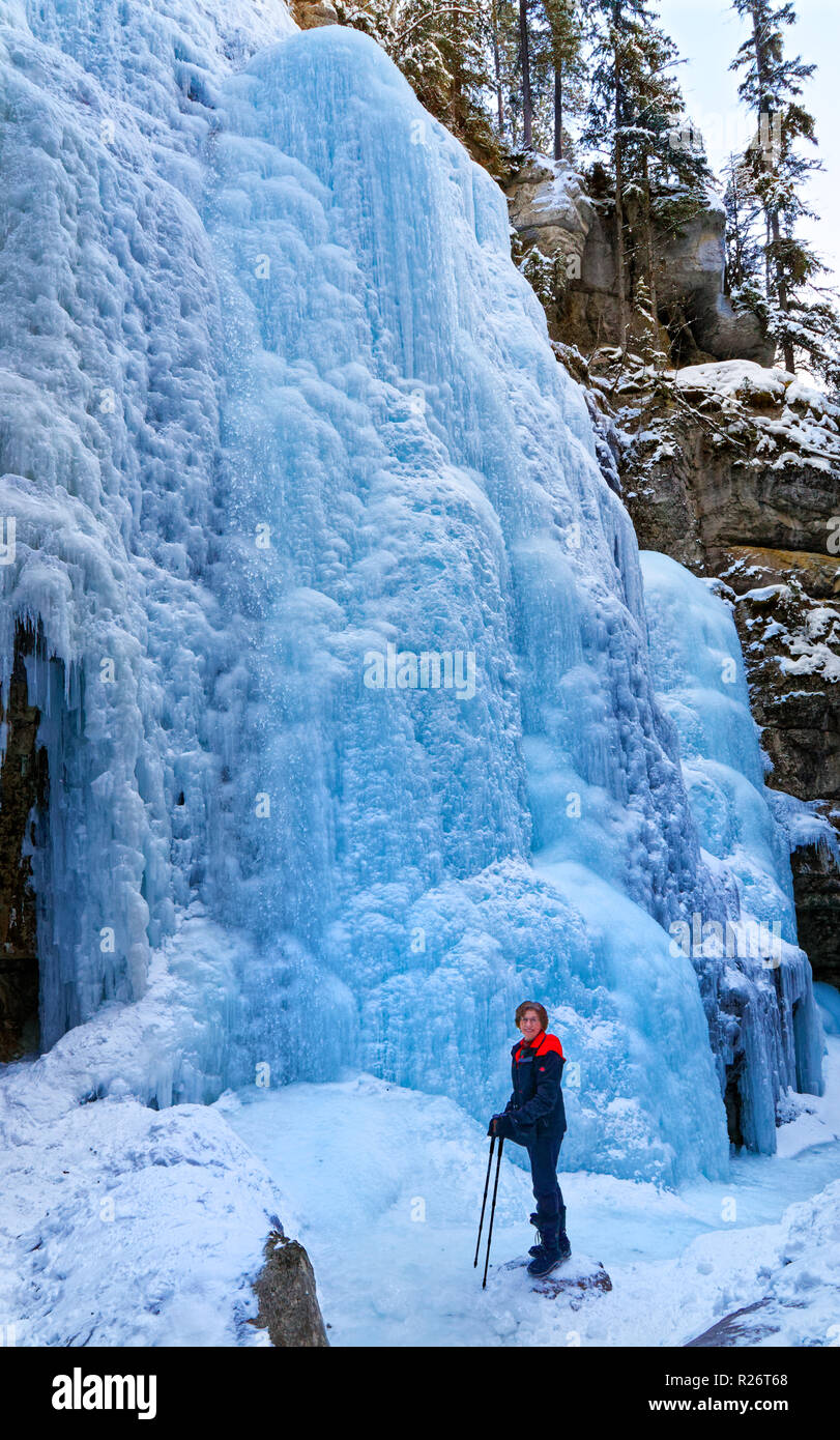 Mujer 42,749.08941 en una profunda nevadas invernales Frozen River Canyon (cañón del río Maligne) mirando hacia las paredes de hielo congelado caídas de hielo Foto de stock