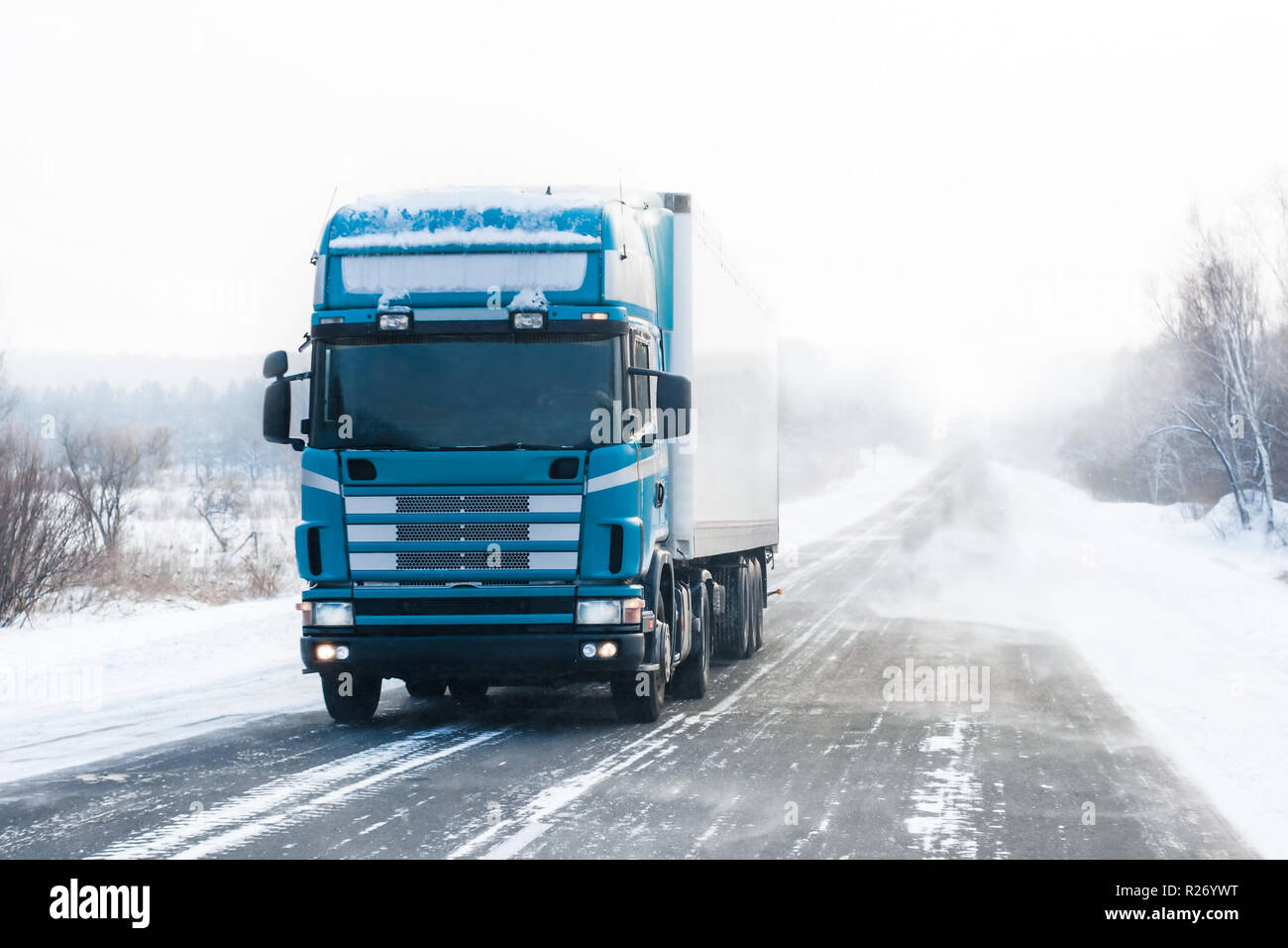 Camión azul que circulan por una carretera de invierno Foto de stock