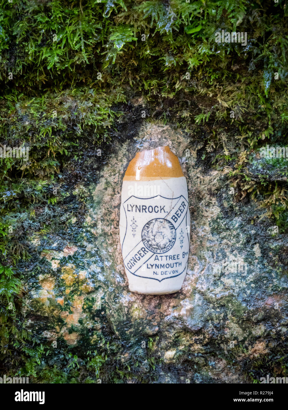 Una vieja botella de cerveza de jengibre Lynrock establecido en una pared en el oeste Lyn River Valley en Lynmouth Exmoor, Devon, Reino Unido en el sitio de un antiguo factor de agua mineral. Foto de stock