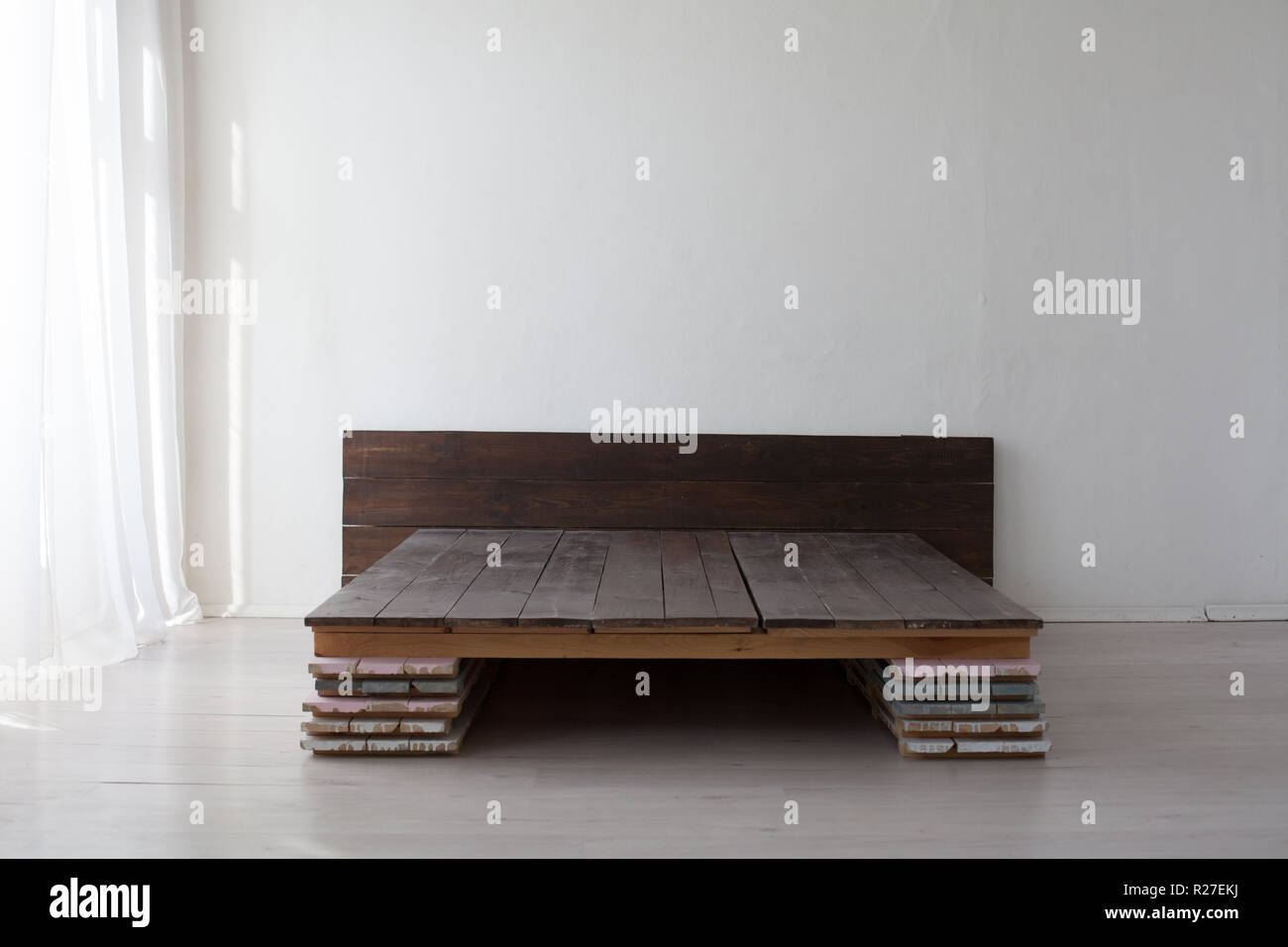 Cama de madera de las tablas sin colchón en una habitación blanca  Fotografía de stock - Alamy