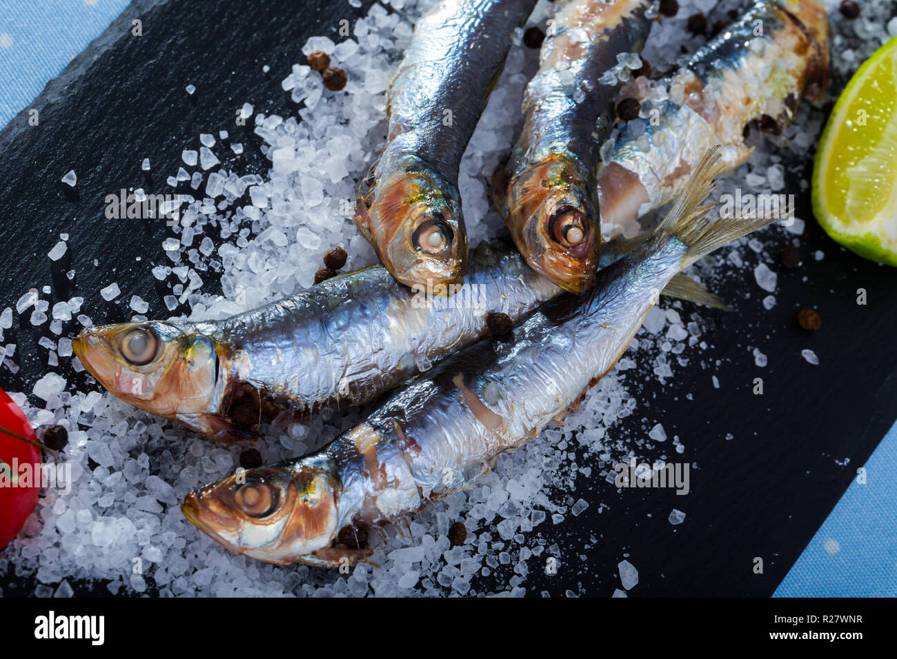 Alimentos saludables. Deliciosas sardinas cocinadas en microondas en la  almohada de sal de mar con especias, limón y el tomate Fotografía de stock  - Alamy