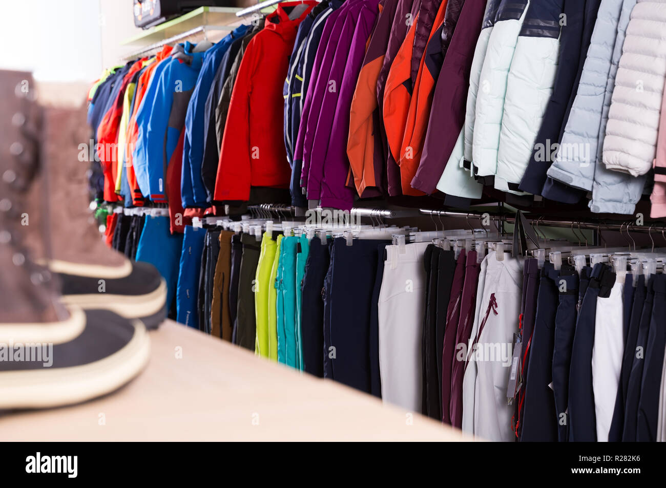 Diversidad ropa esquí para venta en moderna tienda de equipamiento deportivo Fotografía de stock -