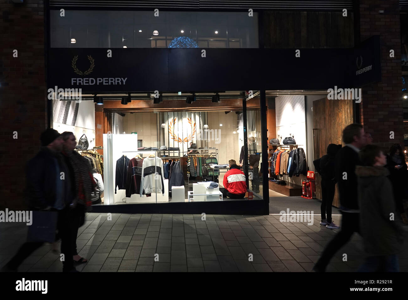 Las personas en silueta caminando por un Fred Perry tienda en Liverpool One  Shopping Complex en la noche. Liverpool, Reino Unido. De noviembre de 2018  Fotografía de stock - Alamy