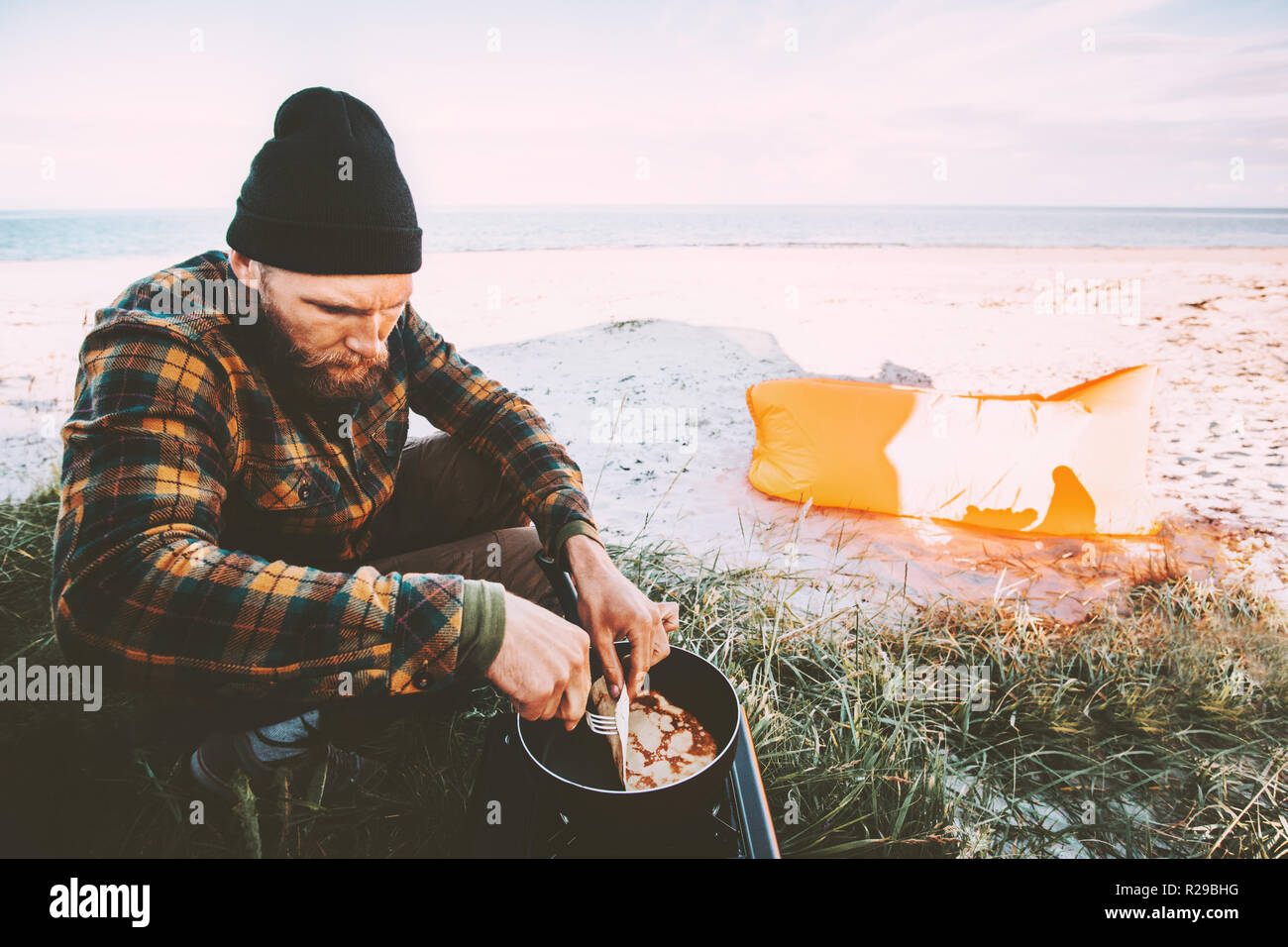 Hombre cocinar panqueques de desayuno de estilo de vida al aire libre Viajes Cocina camping vacaciones en Playa viaje de fin de semana Foto de stock