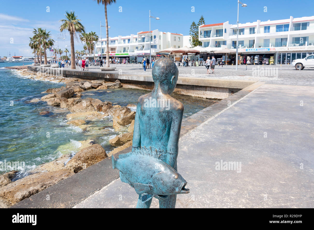 El pequeño pescador" escultura en bronce de un joven con pescado, puerto de Paphos, Paphos (Pafos), Distrito de Pafos, República de Chipre Foto de stock