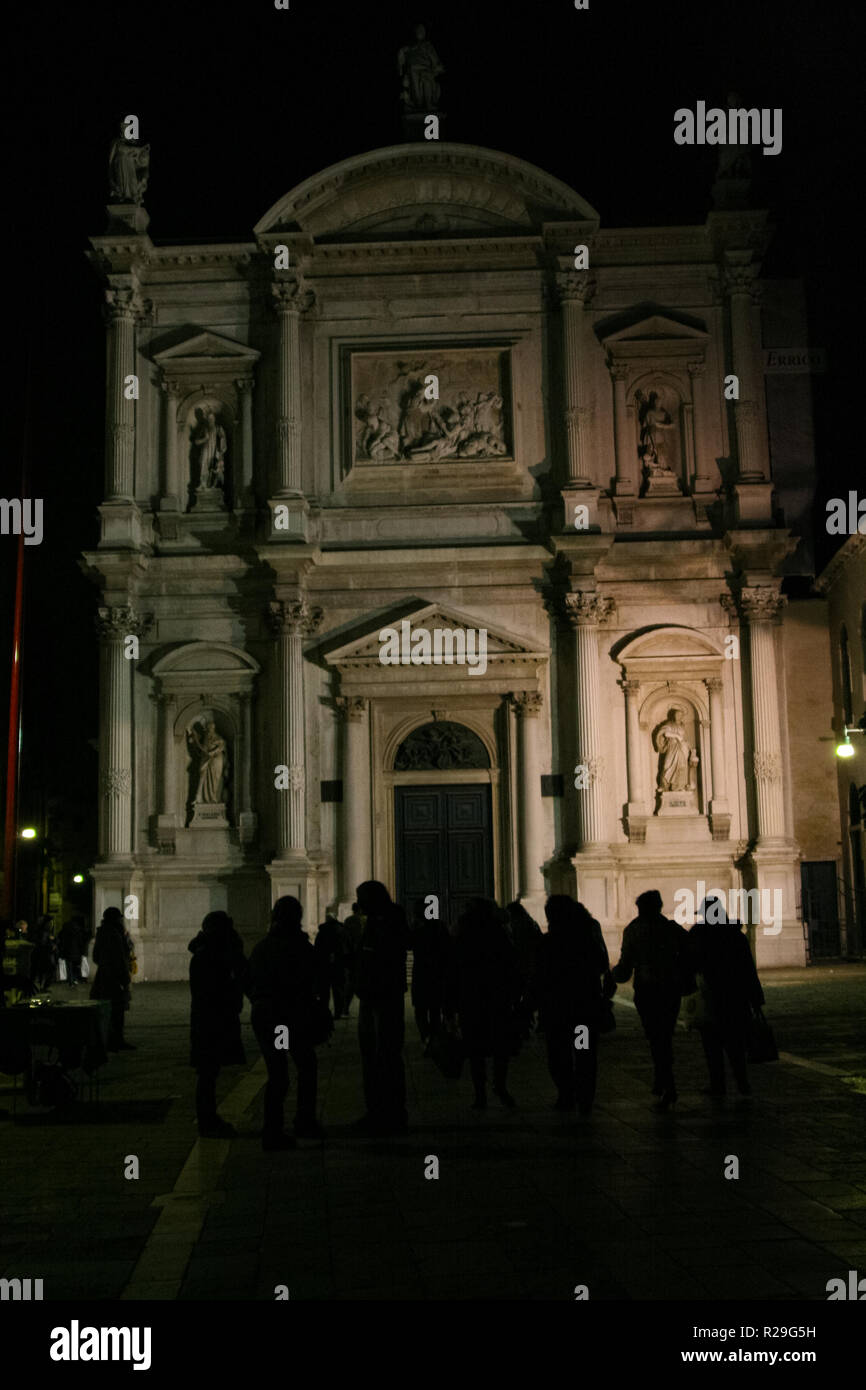 Venecia, la fachada de una iglesia, nocturno, con gente caminando Foto de stock