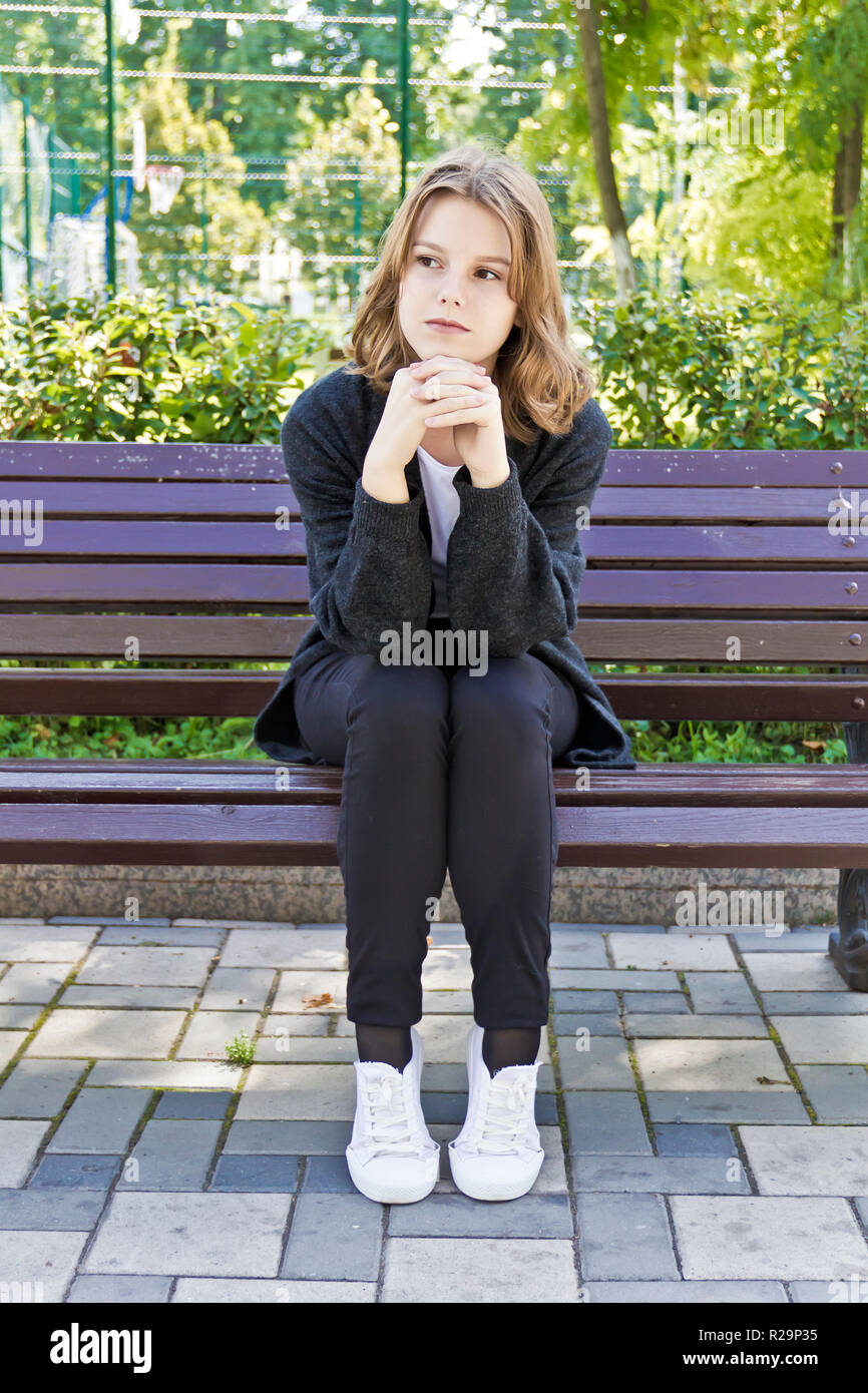 Hermosa niña de 14 años de edad están sentados en el banquillo Fotografía  de stock - Alamy