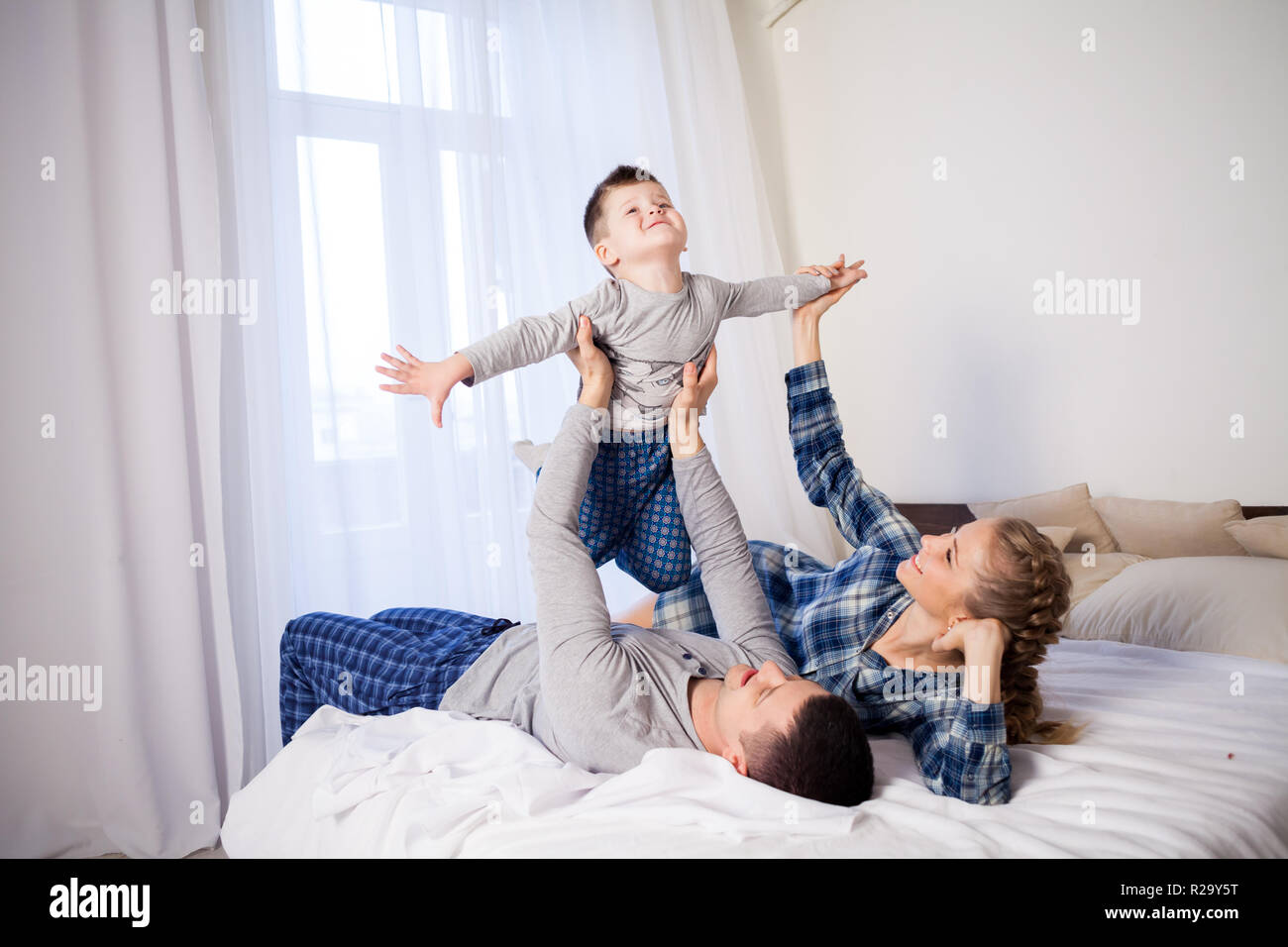 Aplaudir Dinamarca condensador Papá, mamá e hijo de la mañana en la cama desempeñan una familia risa  Fotografía de stock - Alamy