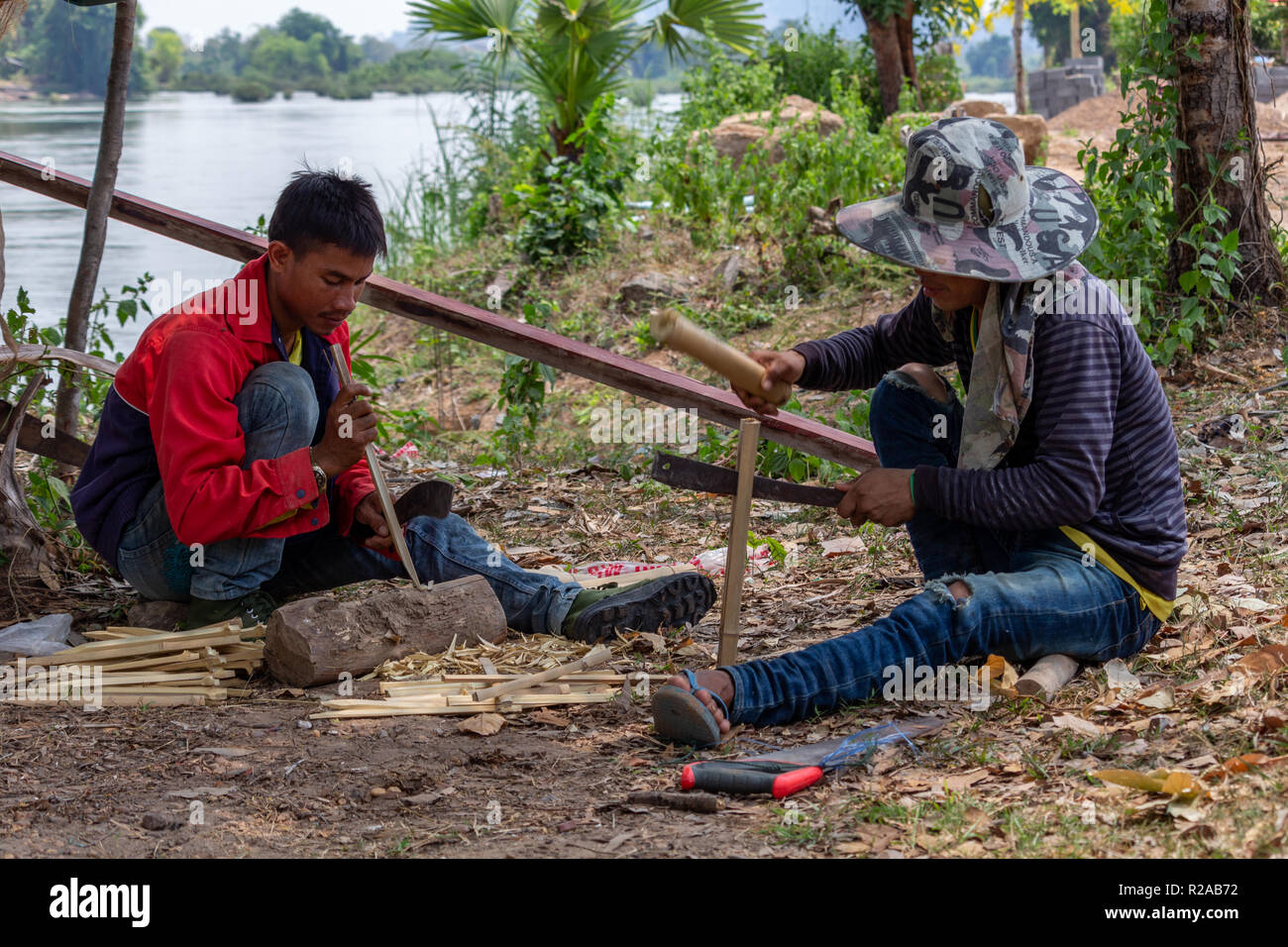 Don Det, Laos - Abril 24, 2018: los hombres locales haciendo trabajos manuales con bambú cerca del río Mekong Foto de stock