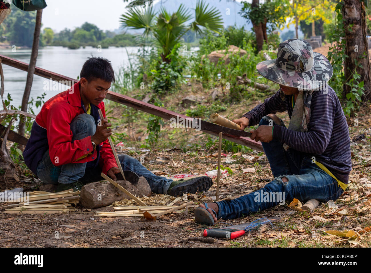 Don Det, Laos - Abril 24, 2018: los hombres locales haciendo trabajos manuales con bambú cerca del río Mekong Foto de stock