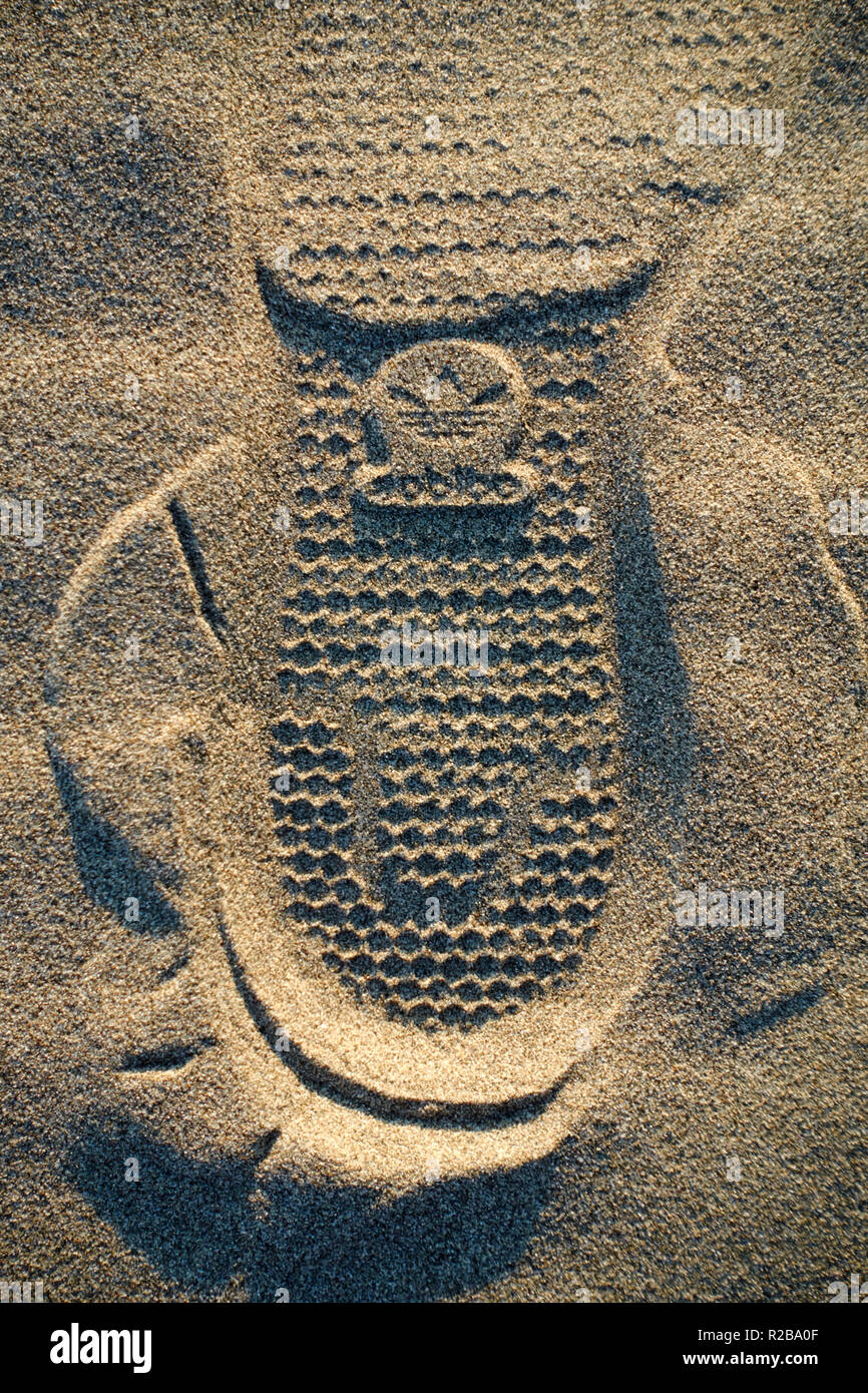 Logotipo de la marca Adidas zapatilla huella sobre la arena de una playa  Fotografía de stock - Alamy