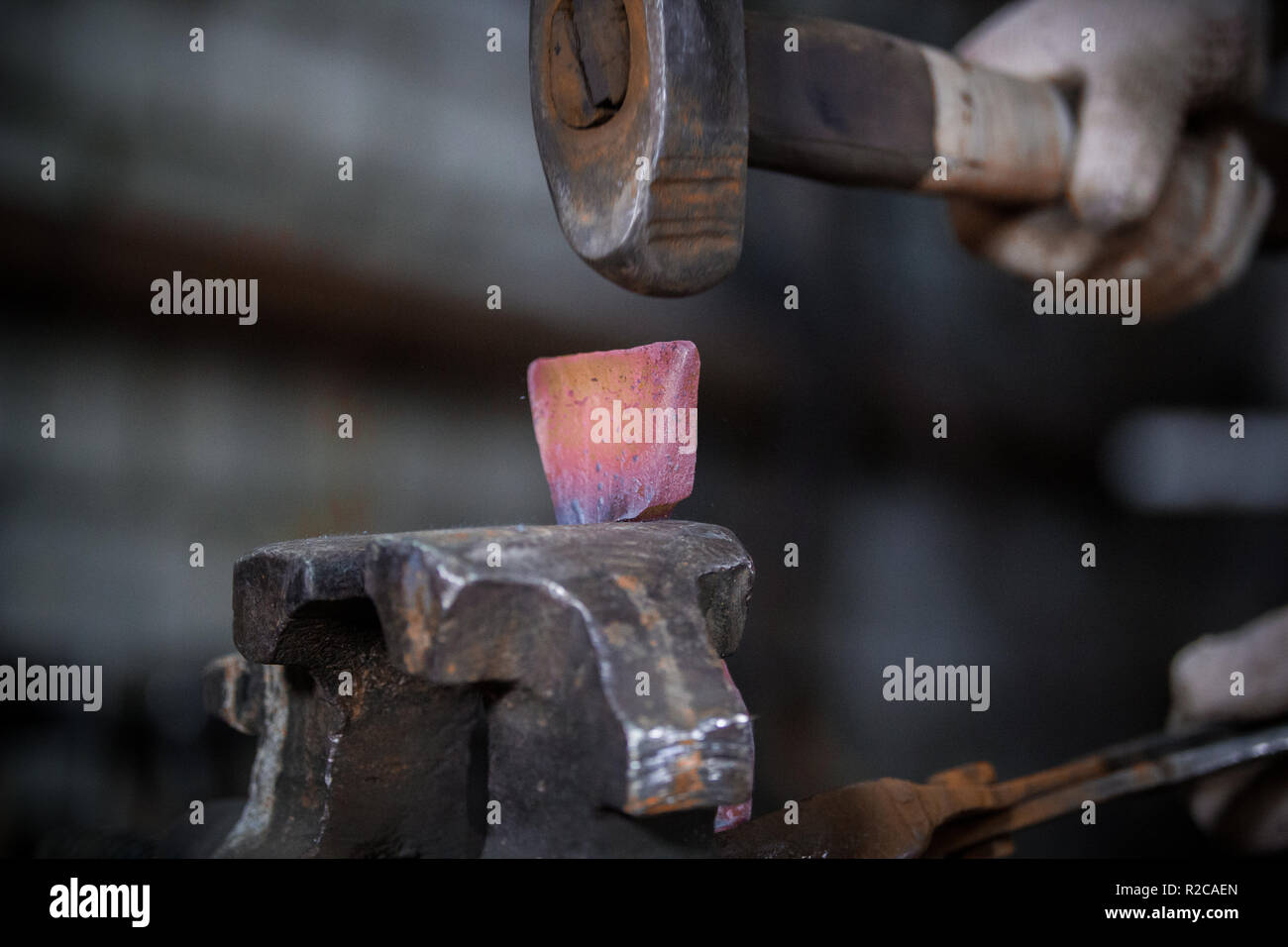 Herrero forja un hierro candente en la forja Fotografía de stock - Alamy