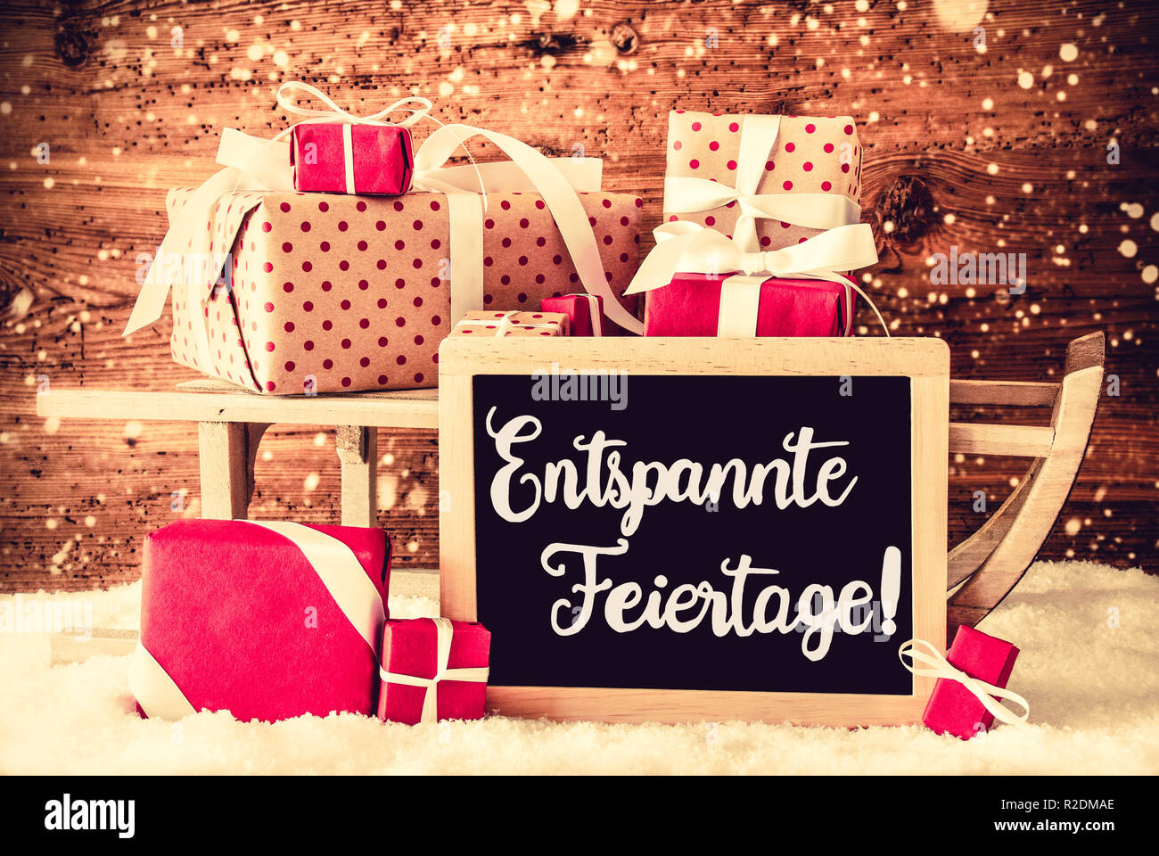 El trineo con regalos, Caligrafía Entspannte Feiertage significa ¡Feliz Navidad! Foto de stock