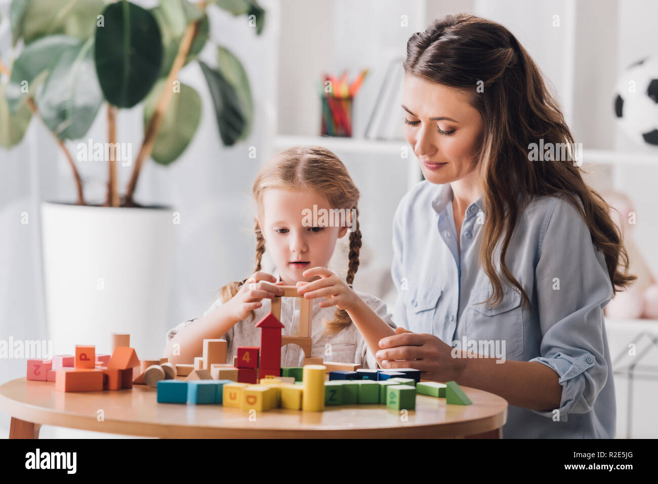 Psicólogo jugando con pequeños bloques de síndrome del niño con autismo Foto de stock