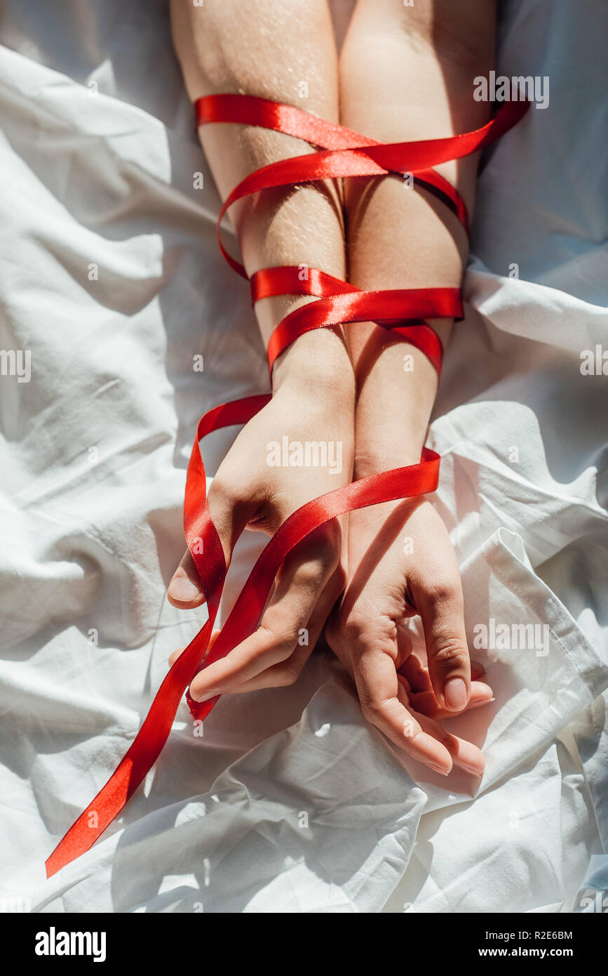 Fotos de Vista Parcial Mujer Atada Con Cinta Seda Sobre Fondo Rojo - Imagen  de © AntonMatyukha #253867618