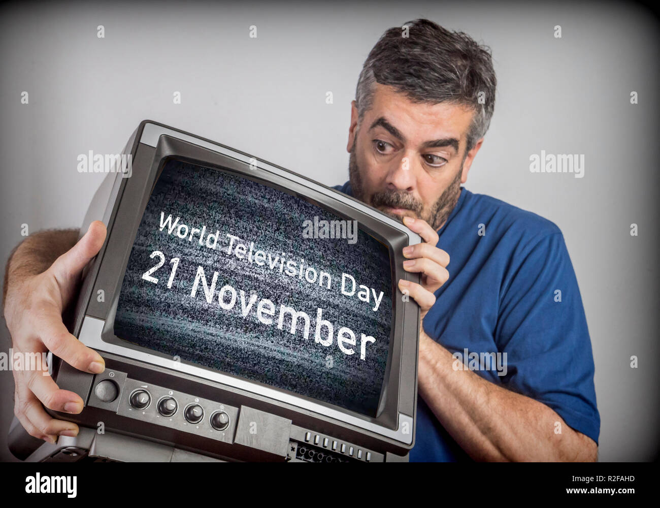Hombre de mediana edad tiene un TV con el Día Mundial de la Televisión 21 de noviembre de pantalla, imagen conceptual Foto de stock