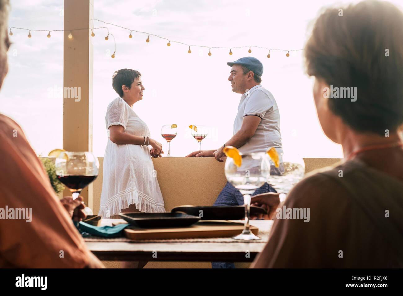 Escena romántica y el amor con la pareja de mediana edad del Cáucaso en el fondo hablando y permanecer juntos en relación después de una cena con amigos. fondo de cielo blanco y celebración con la primera fecha concepto para gente agradable coqueteo Foto de stock