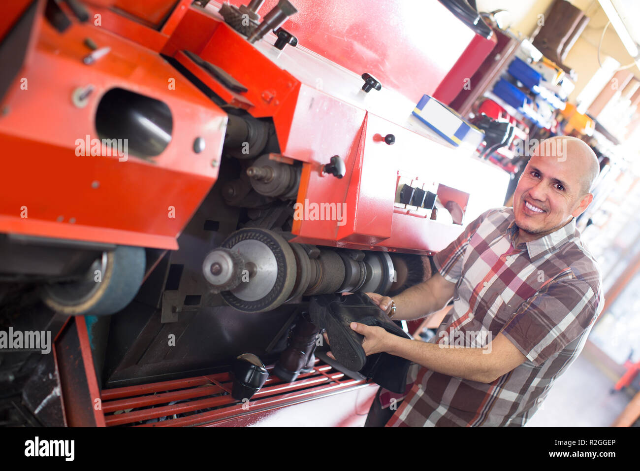 Artesano profesional calzado pulido en la máquina en el atelier de zapata Foto de stock