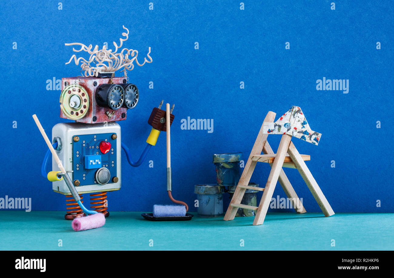 Gracioso robotic pintor decorador interior listo para mantenimiento. Escalera de madera, rodillo de pintura y cucharas contra la pared de color azul. Foto de stock