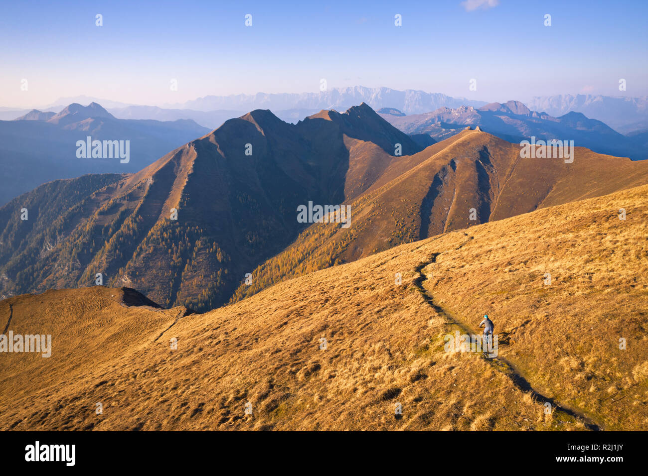 Vista aérea de una mujer el ciclismo de montaña en los Alpes, Gastein, Salzburgo, Austria Foto de stock