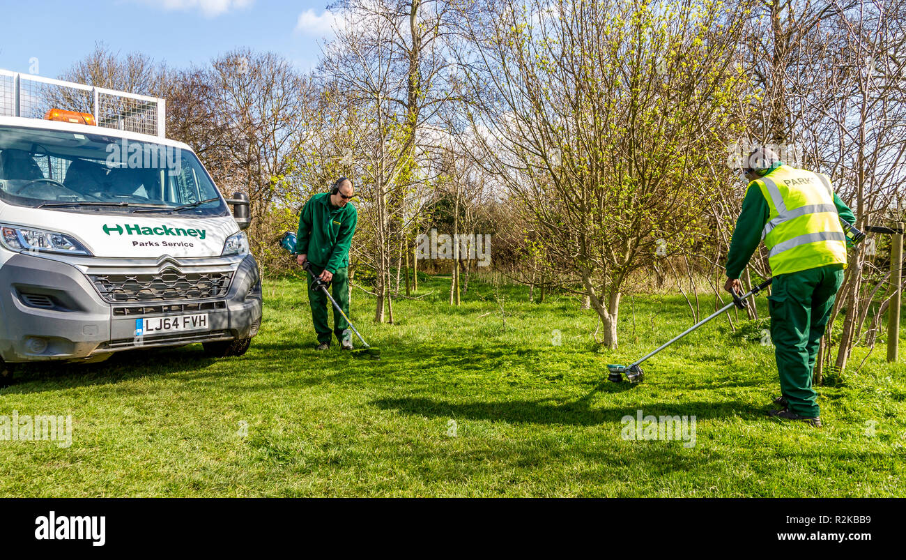 Hackney, Londres, parques dept utilizando Makita strimmers alimentado por batería Foto de stock