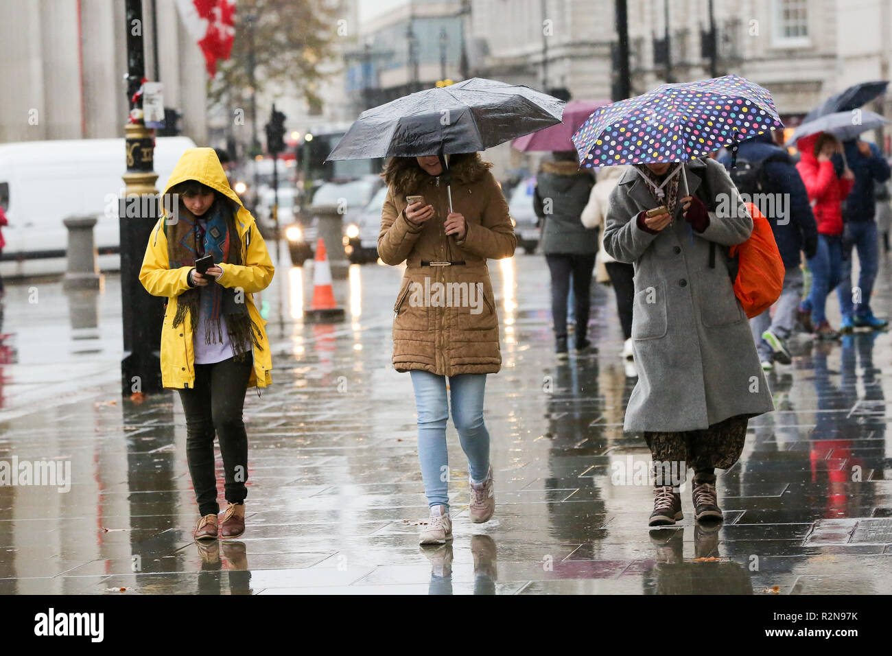 Las personas se ven sosteniendo un paraguas durante una lluvia pesada. Según Met Office, la y el aguanieve se proyectó en Gran Bretaña esta semana, ya que las temperaturas